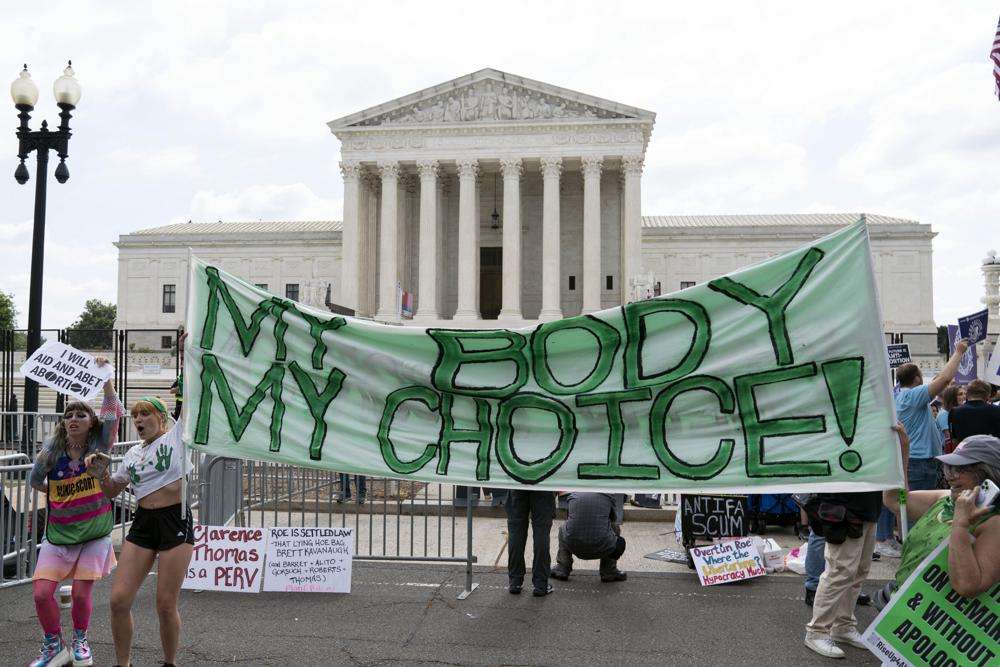 Abortion right activists gather outside the Supreme Court in Washington, Friday. The Supreme Court has ended constitutional protections for abortion that had been in place nearly 50 years, a decision by its conservative majority to overturn the court's landmark abortion cases.