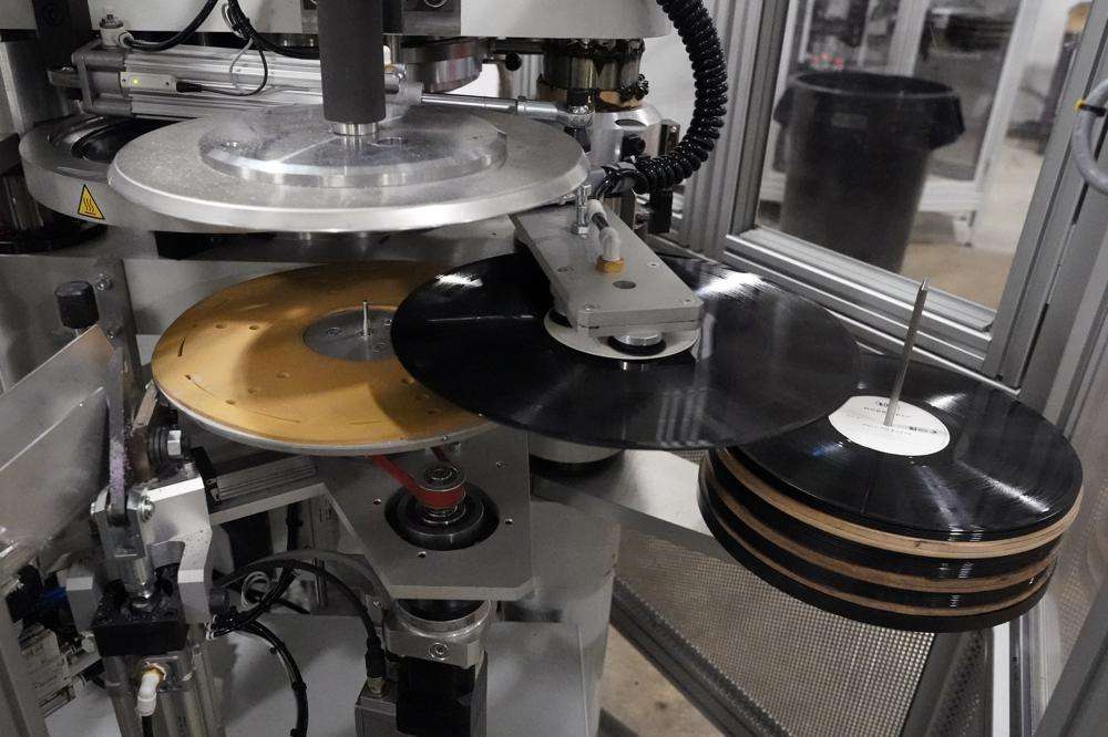 Freshly pressed vinyl records are produced in a stamper at the United Record Pressing facility Thursday in Nashville, Tenn. The arrival of the compact disc nearly killed off record albums. Four decades later, with resuscitated record album sales producing double-digit growth, manufacturers are rapidly rebuilding an industry to keep pace with sales that topped $1 billion last year.
