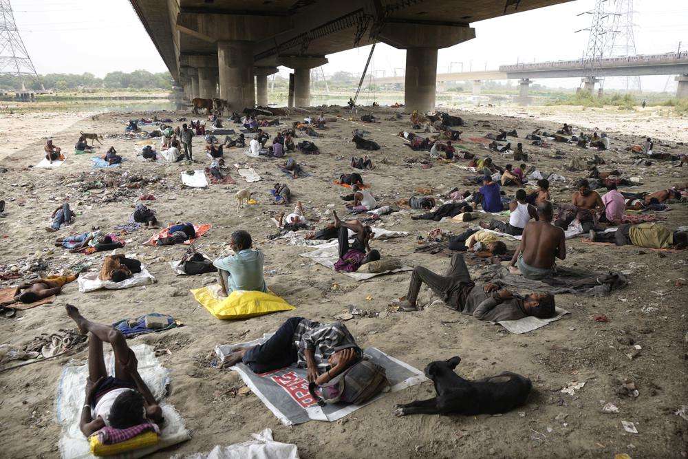 Homeless people sleep in the shade of an overbridge on a hot day in New Delhi, May 20. The Indian capital and surrounding areas are facing extreme heat wave conditions.
