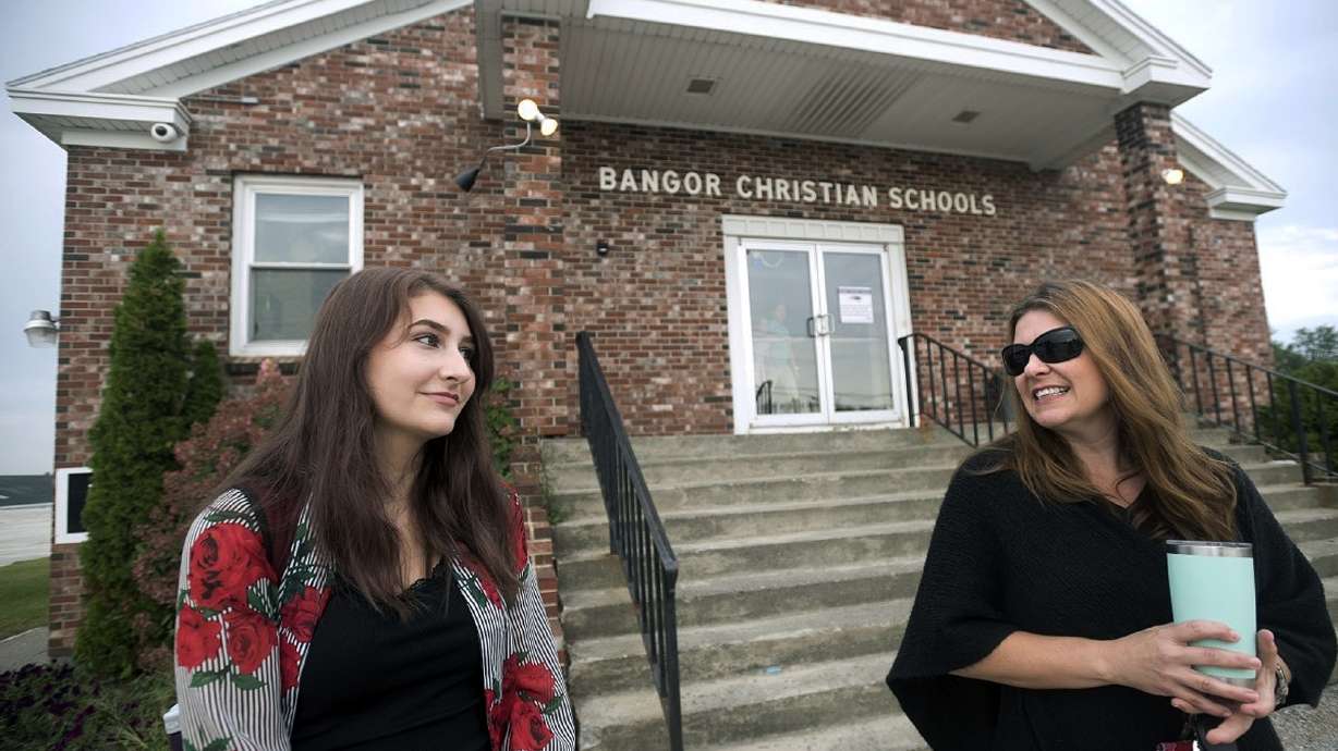 Bangor Christian Schools sophomore Olivia Carson, 15, of Glenburn, Maine, left, stands with her mother Amy while getting dropped off on the first day of school on August 28, 2018 in Bangor, Maine.