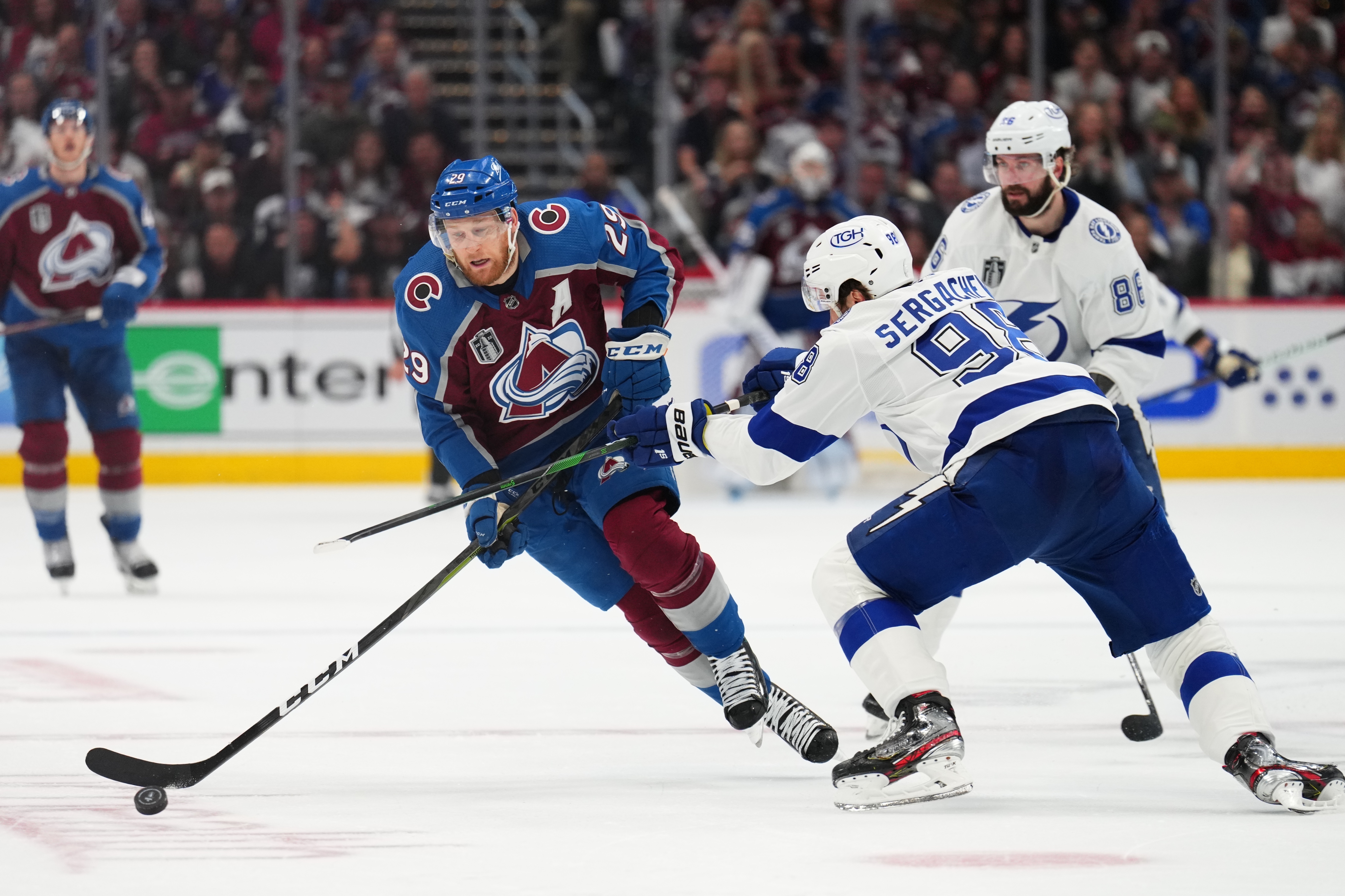 Colorado Avalanche center Nathan MacKinnon (29) moves the puck against Tampa Bay Lightning defenseman Mikhail Sergachev (98) during the second period in Game 5 of the NHL hockey Stanley Cup Final, Friday, June 24, 2022, in Denver. 
