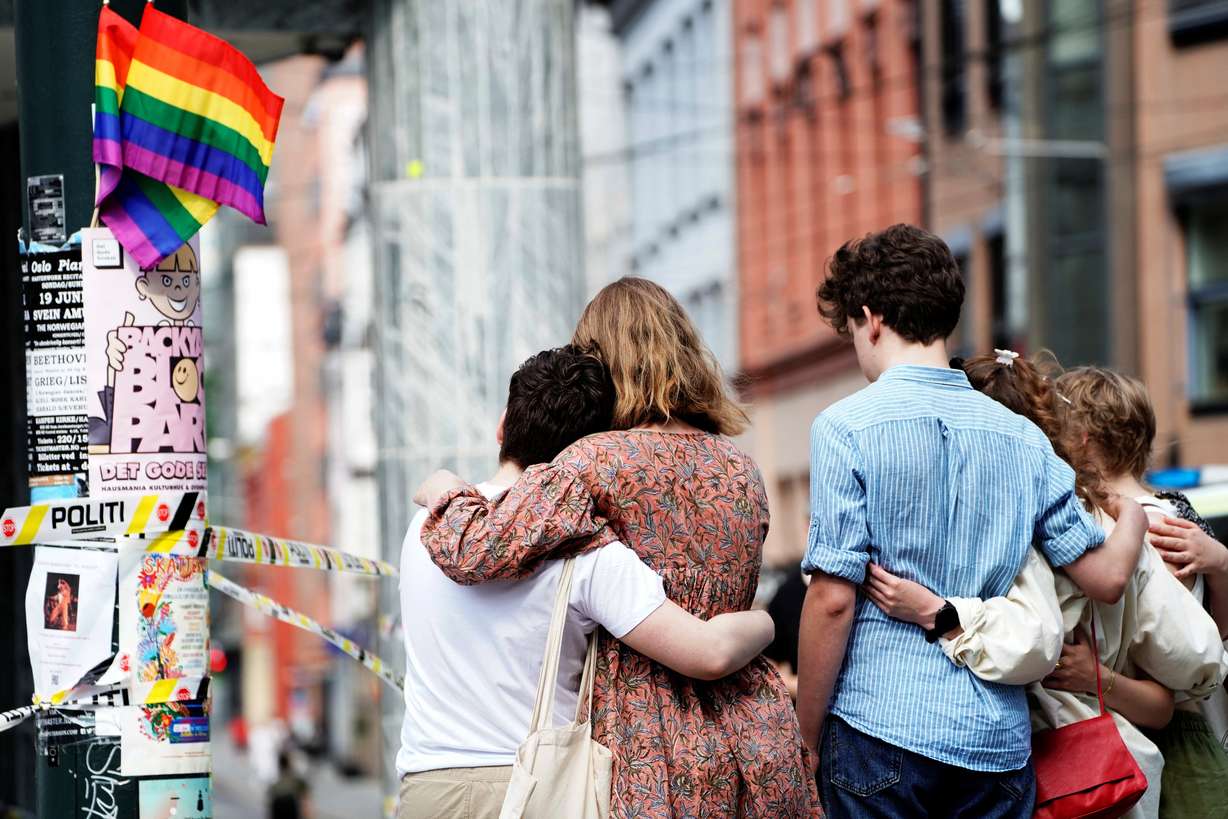 People embrace near the police line following a shooting at the London Pub, a popular gay bar and nightclub, in central Oslo, Norway, on Saturday.