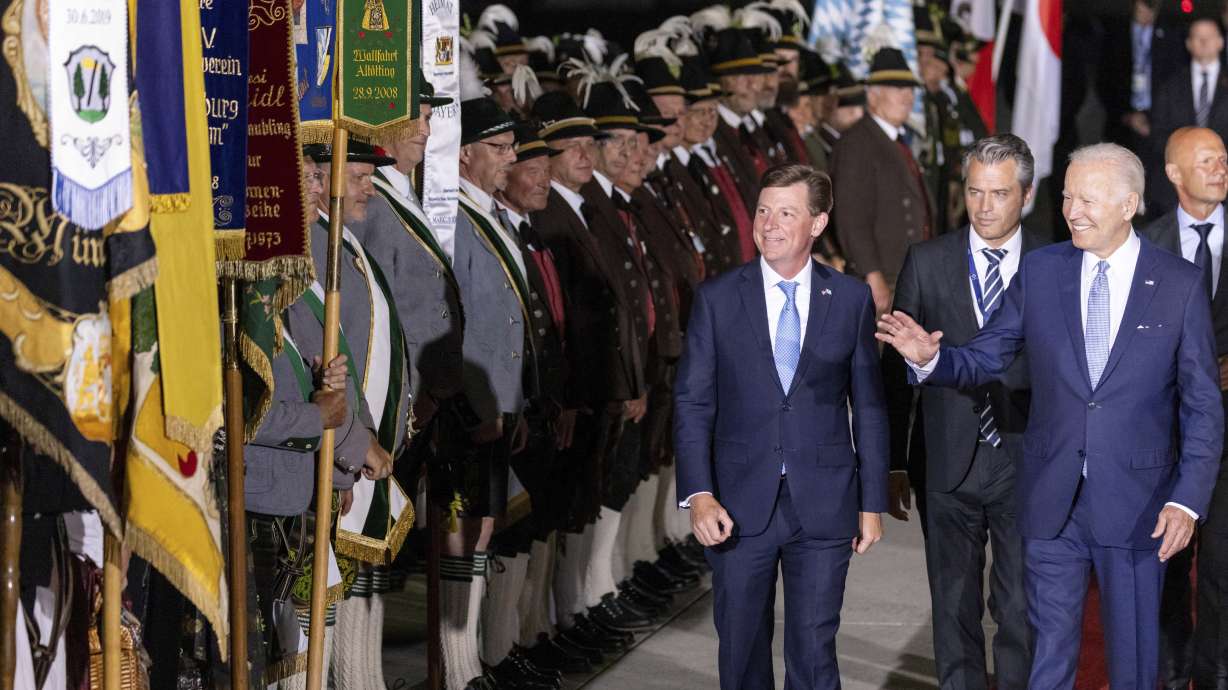 U.S. President Joe Biden, right, waves as he walks past Bavarian mountain riflemen and traditional costumers after his arrival at Franz-Josef-Strauss Airport near Munich, Germany, Saturday ahead of the G7 summit. Biden is in Germany to attend a Group of Seven summit of leaders of the world's major industrialized nations.