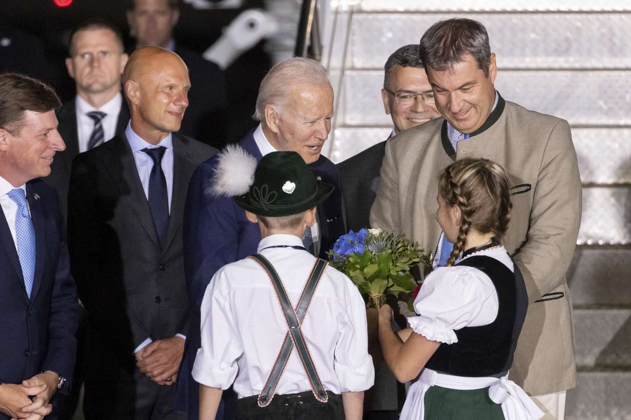 Children Daniela Hauser and Marco Keller greet U.S. President Joe Biden, center, with a bouquet of flowers on his arrival at Franz-Josef-Strauss Airport near Munich, Germany, Saturday, ahead of the G7 summit. Bavarian Prime Minister Markus Soeder is on the right. Biden is in Germany to attend a Group of Seven summit of leaders of the world's major industrialized nations.
