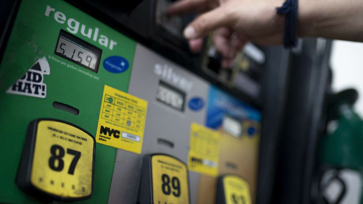 Wallace Reid purchases fuel for the vehicle he drives to make a living using ride-share apps, Wednesday in the Queens borough of New York.
