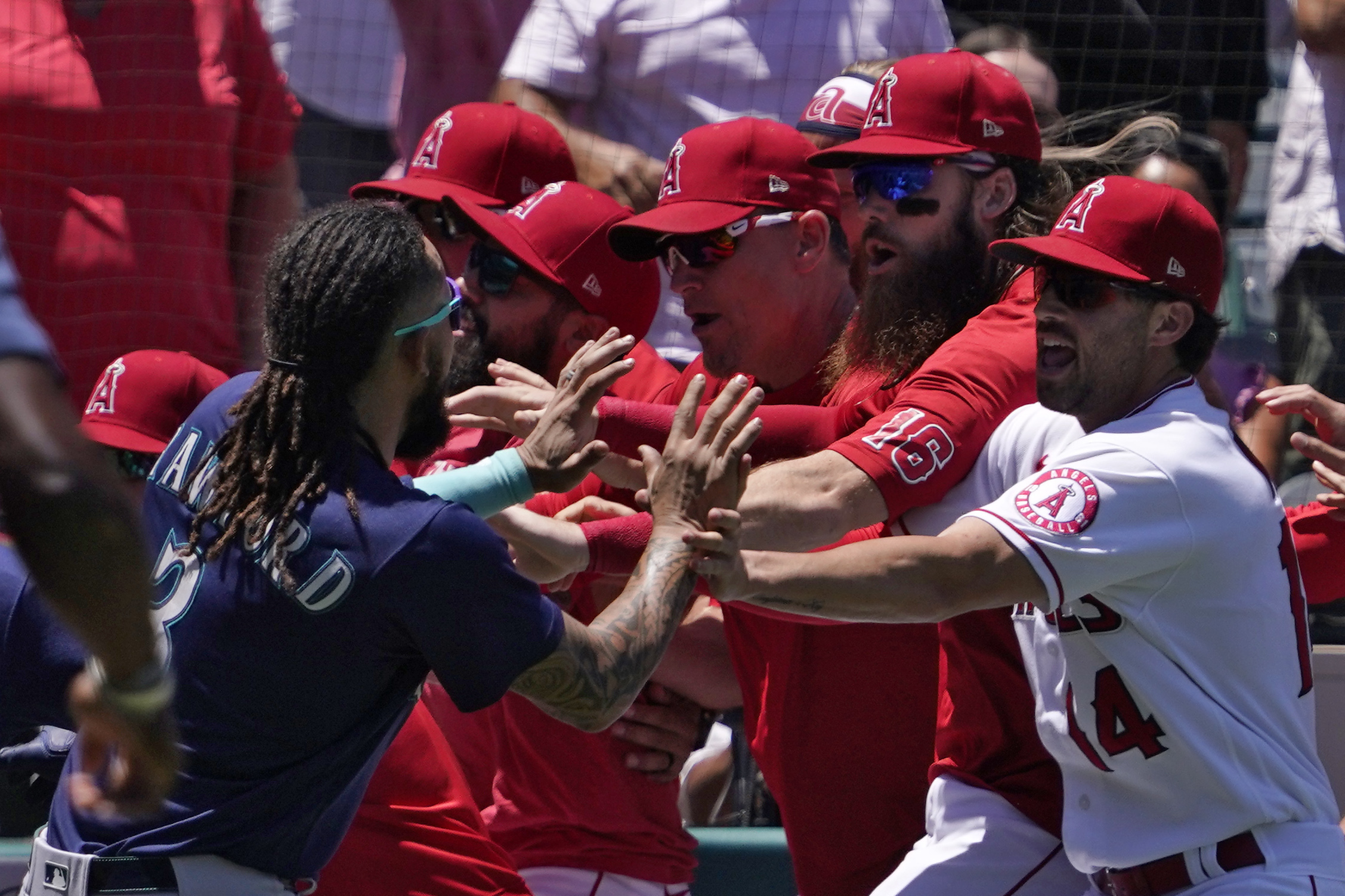 Seattle Mariners' J.P. Crawford, left, and several members of the Los Angeles Angels scuffle after Mariners' Jesse Winker was hit by a pitch during the second inning of a baseball game Sunday, June 26, 2022, in Anaheim, Calif. 