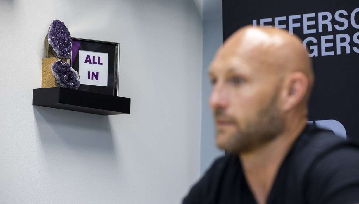 The phrase “All In” is pictured behind Jefferson Rogers, owner of JKR Windows, as he talks about his path from addiction to success at his office in Draper on Wednesday, June 15.