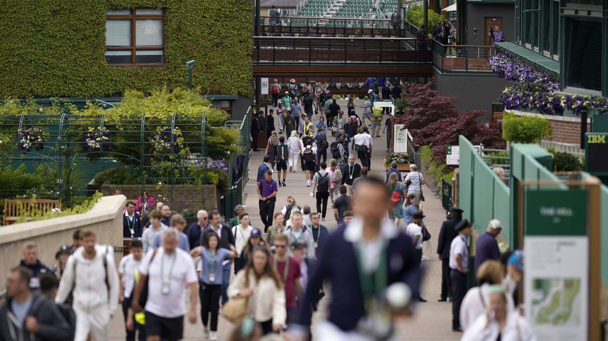 Spectators arrive at the courts on day one of the Wimbledon tennis championships in London, Monday, June 27, 2022.