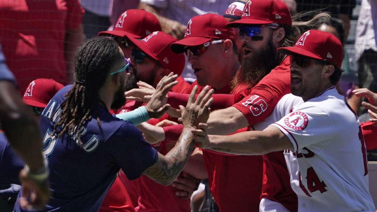 Seattle Mariners' J.P. Crawford, left, and several members of the Los Angeles Angels scuffle after Mariners' Jesse Winker was hit by a pitch during the second inning of a baseball game Sunday, June 26, 2022, in Anaheim, Calif.