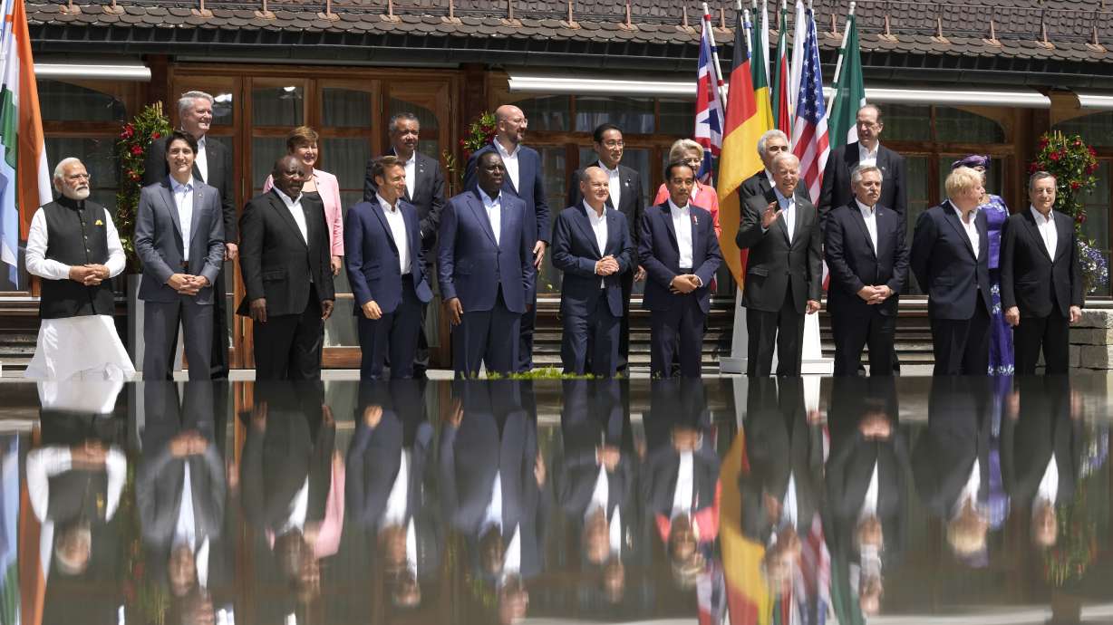 President Joe Biden, front fourth right, waves as he poses with G7 leaders and Outreach guests for an official group photo at Castle Elmau in Kruen, near Garmisch-Partenkirchen, Germany, on Monday.