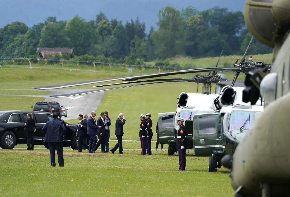 President Joe Biden, center, salutes as he prepares to board Marine One at a landing zone near Ohlstadt, Germany, Tuesday, after attending the Group of Seven meeting at the Schloss Elmau hotel in Elmau, Germany.