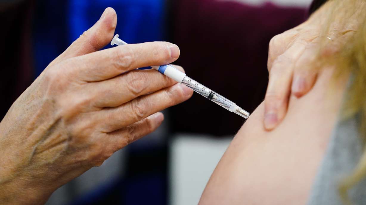 A health worker administers a dose of a COVID-19 vaccine in Chester, Pa., on Dec. 15, 2021. At least some U.S. adults may get updated COVID-19 shots this fall, as government advisers voted Tuesday that it's time to tweak booster doses to better match the most recent virus variants.