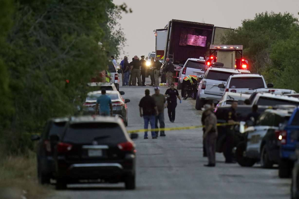 Police and other first responders work the scene where officials say dozens of people have been found dead and multiple others were taken to hospitals with heat-related illnesses after a semitrailer containing suspected migrants was found, Monday, in San Antonio.