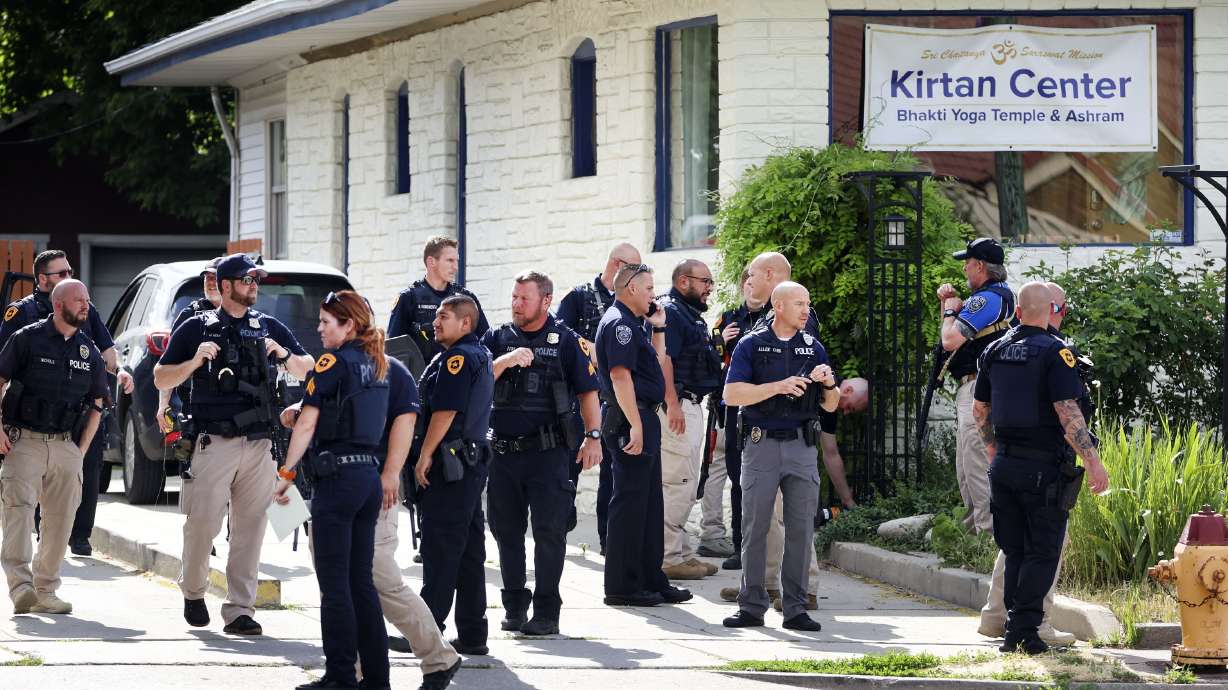 Police gather at the scene of a yoga studio where a man was arrested Wednesday after police say he fired shots from his vehicle at a home and later near Salt Lake County businesses.