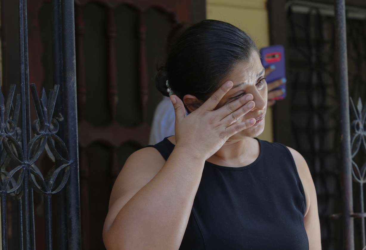 Karen Caballero, the mother of Fernando Redondo Caballero and Alejandro Andino Caballero who died near San Antonio, Texas after being discovered in a hot trailer full of migrants being smuggled into the US, wipes a tear during an impromptu conference at their home in Las Vegas, Honduras, Wednesday.