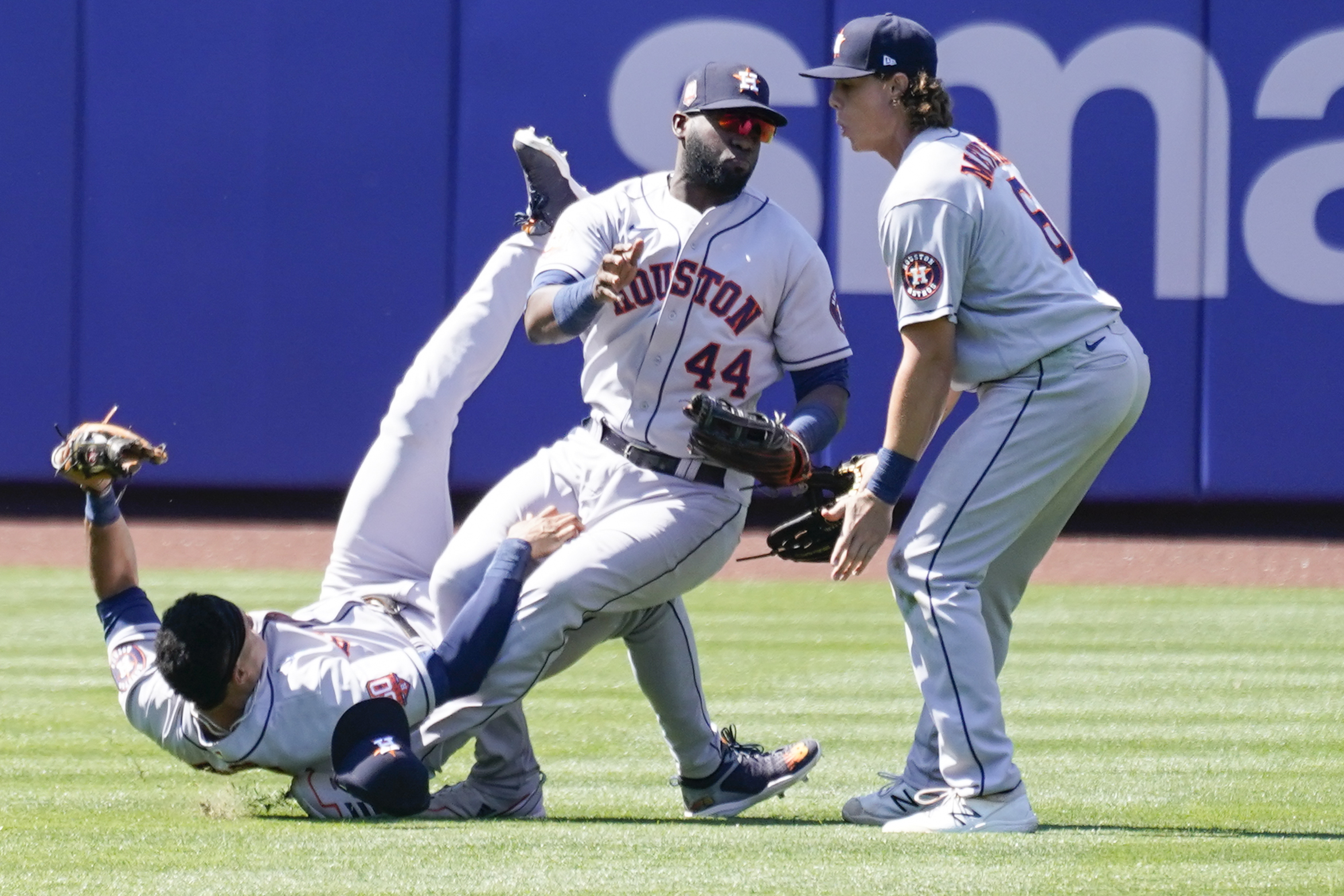 Houston Astros' Jake Meyers (6) watches as Jeremy Pena, left, and Yordan Alvarez (44) fall to the ground after colliding catching a fly ball by New York Mets' Dominic Smith during the eighth inning of a baseball game, Wednesday, June 29, 2022, in New York. 