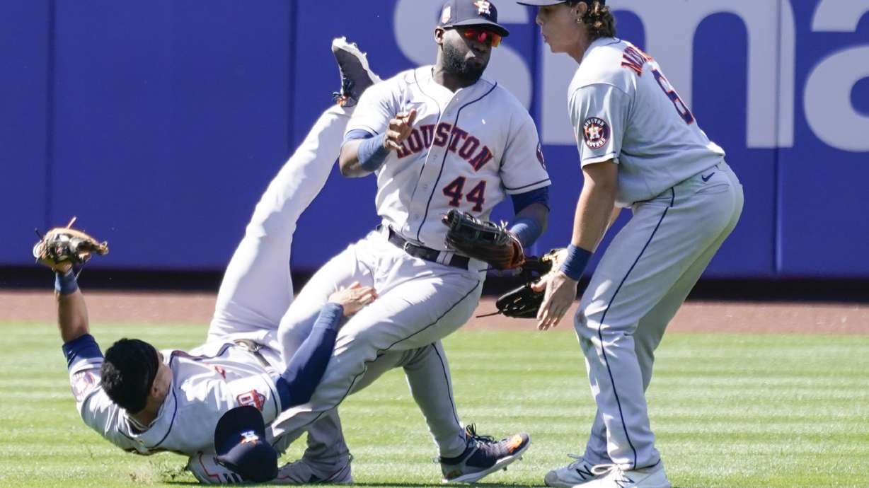 Houston Astros' Jake Meyers (6) watches as Jeremy Pena, left, and Yordan Alvarez (44) fall to the ground after colliding catching a fly ball by New York Mets' Dominic Smith during the eighth inning of a baseball game, Wednesday, June 29, 2022, in New York.