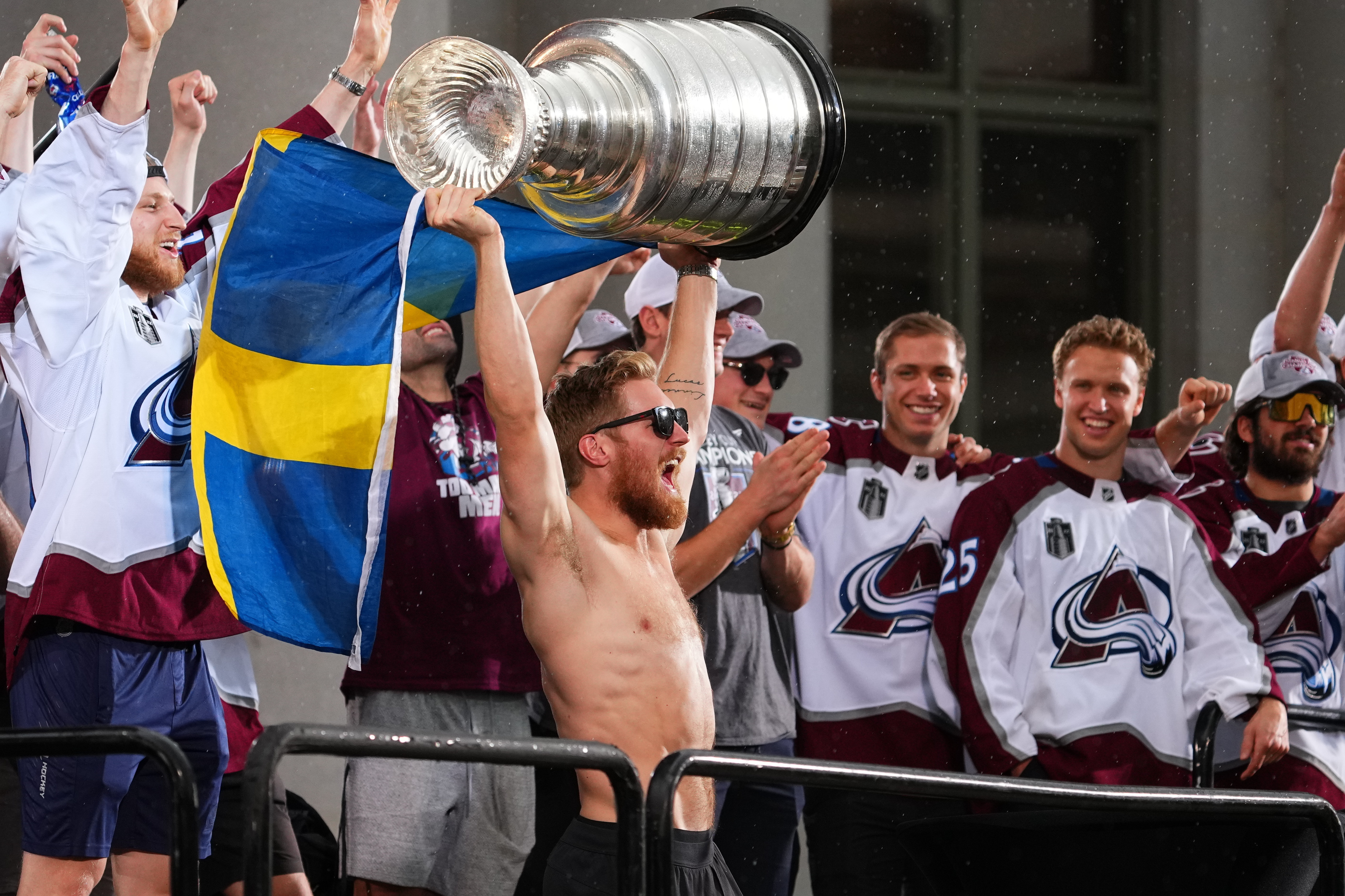 Colorado Avalanche left wing Gabriel Landeskog hoists the Stanley Cup and a flag of Sweden at a rally for the NHL hockey champions Thursday, June 30, 2022, in Denver. 