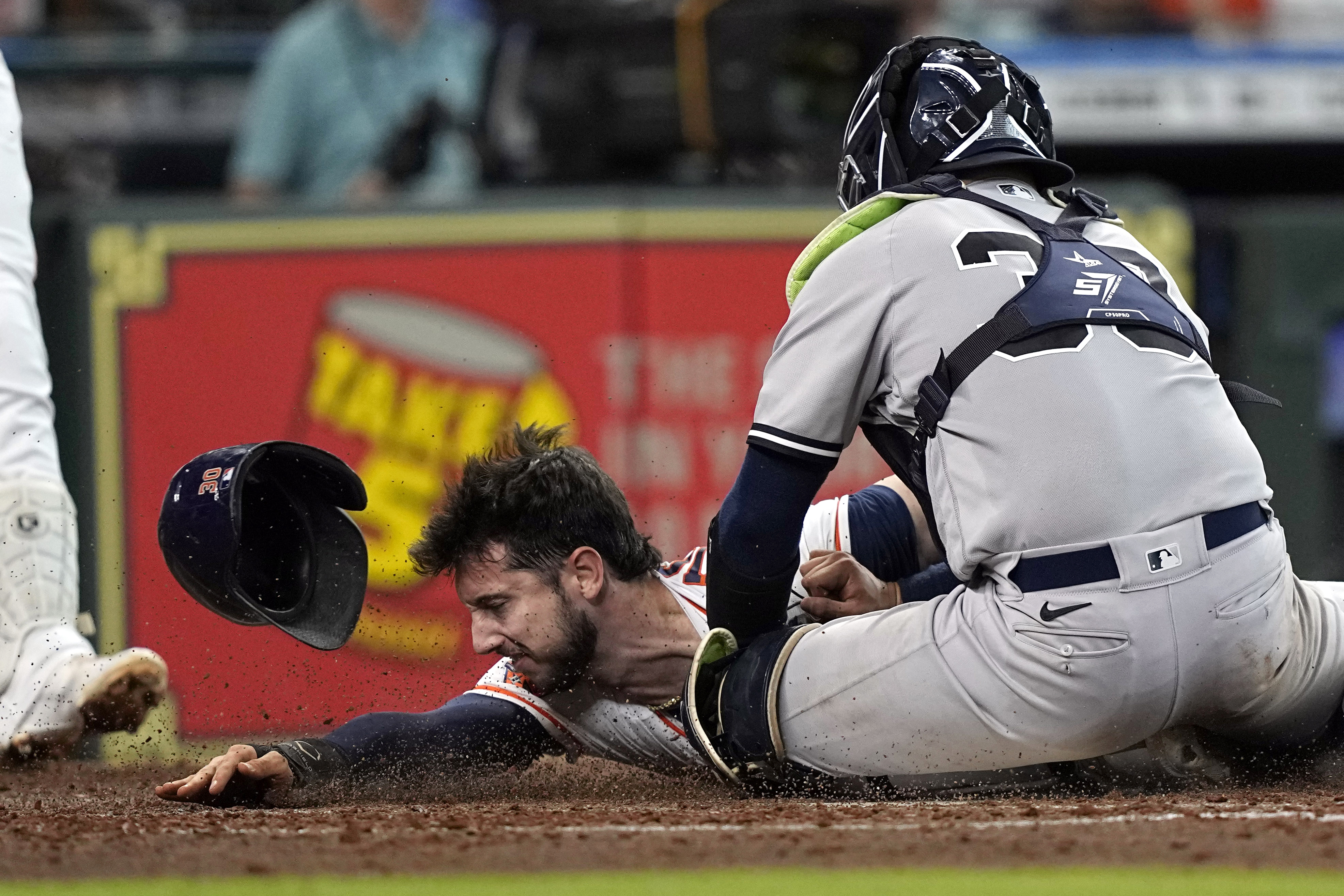 Houston Astros' Kyle Tucker, left, is tagged out by New York Yankees catcher Jose Trevino (39) while trying to steal home plate during the third inning of a baseball game Thursday, June 30, 2022, in Houston. 