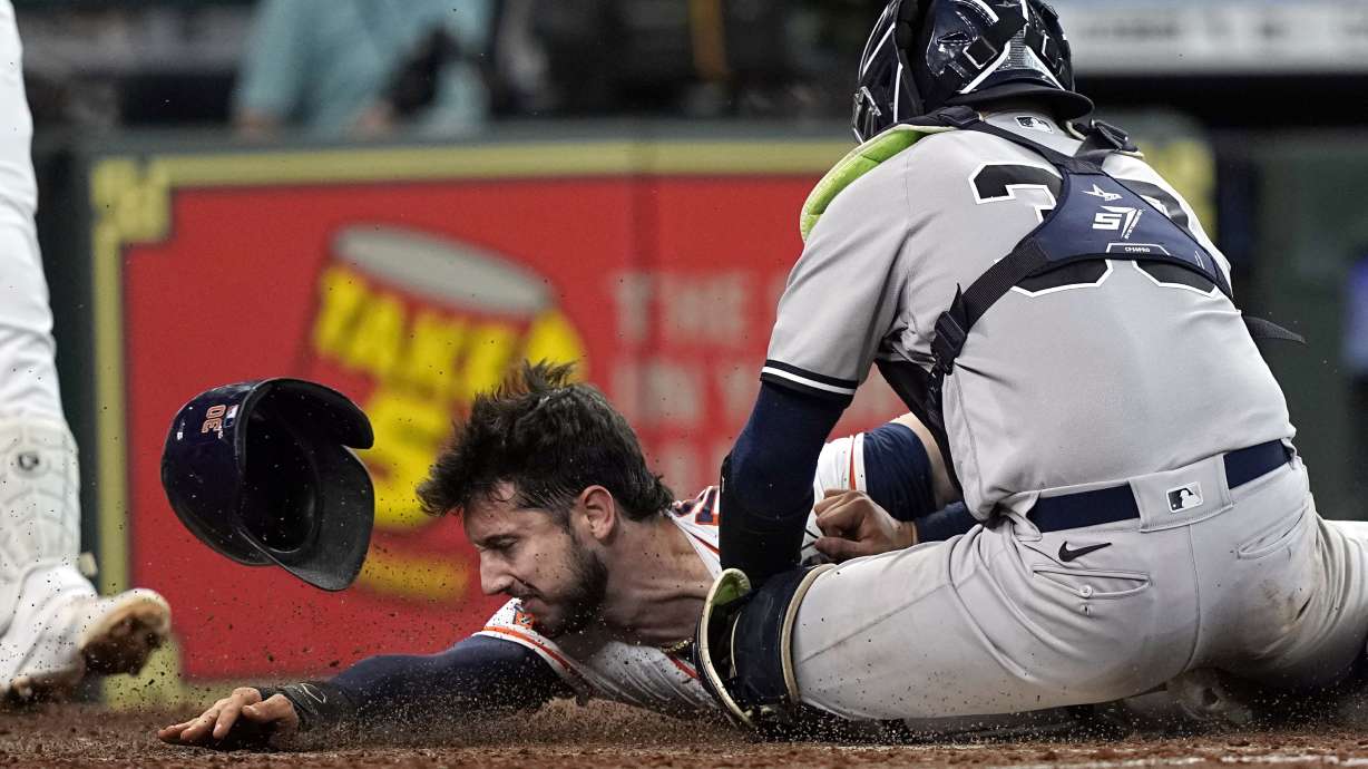 Houston Astros' Kyle Tucker, left, is tagged out by New York Yankees catcher Jose Trevino (39) while trying to steal home plate during the third inning of a baseball game Thursday, June 30, 2022, in Houston.