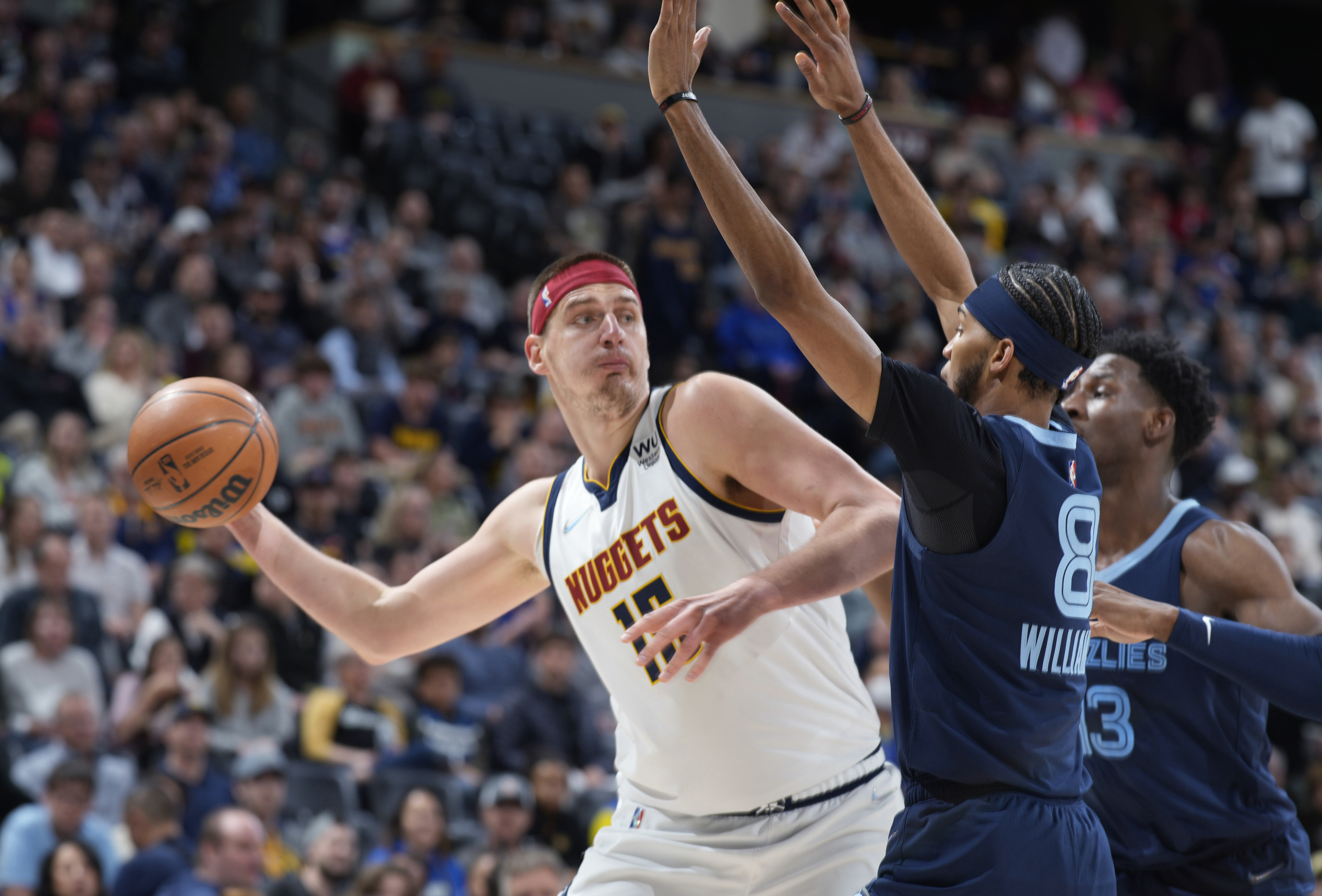 FILE - Denver Nuggets center Nikola Jokic looks to pass the ball as Memphis Grizzlies guard Ziaire Williams, front, and forward Jaren Jackson Jr. defend during the first half of an NBA basketball game April 7, 2022, in Denver. Jokic and the Nuggets agreed Thursday, June 30, to a $264 supermax extension, according to a person with direct knowledge of the negotiations who spoke to The Associated Press on condition of anonymity because neither the player nor team announced the agreement. 