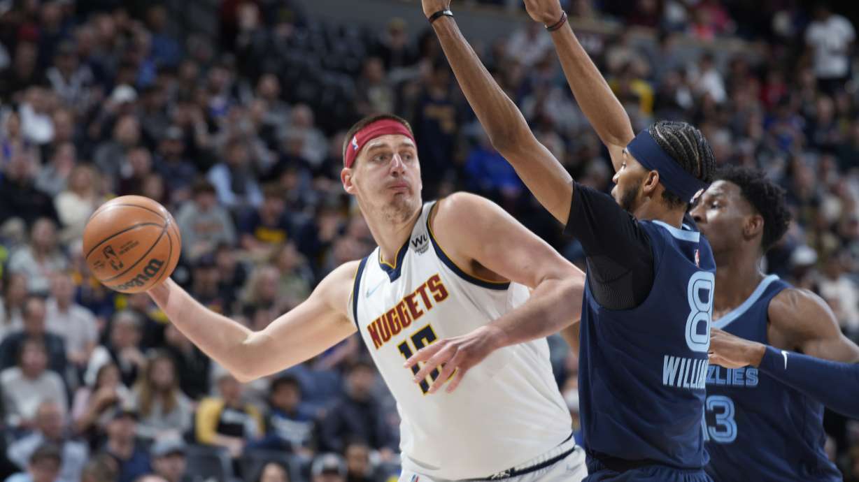 FILE - Denver Nuggets center Nikola Jokic looks to pass the ball as Memphis Grizzlies guard Ziaire Williams, front, and forward Jaren Jackson Jr. defend during the first half of an NBA basketball game April 7, 2022, in Denver. Jokic and the Nuggets agreed Thursday, June 30, to a $264 supermax extension, according to a person with direct knowledge of the negotiations who spoke to The Associated Press on condition of anonymity because neither the player nor team announced the agreement.