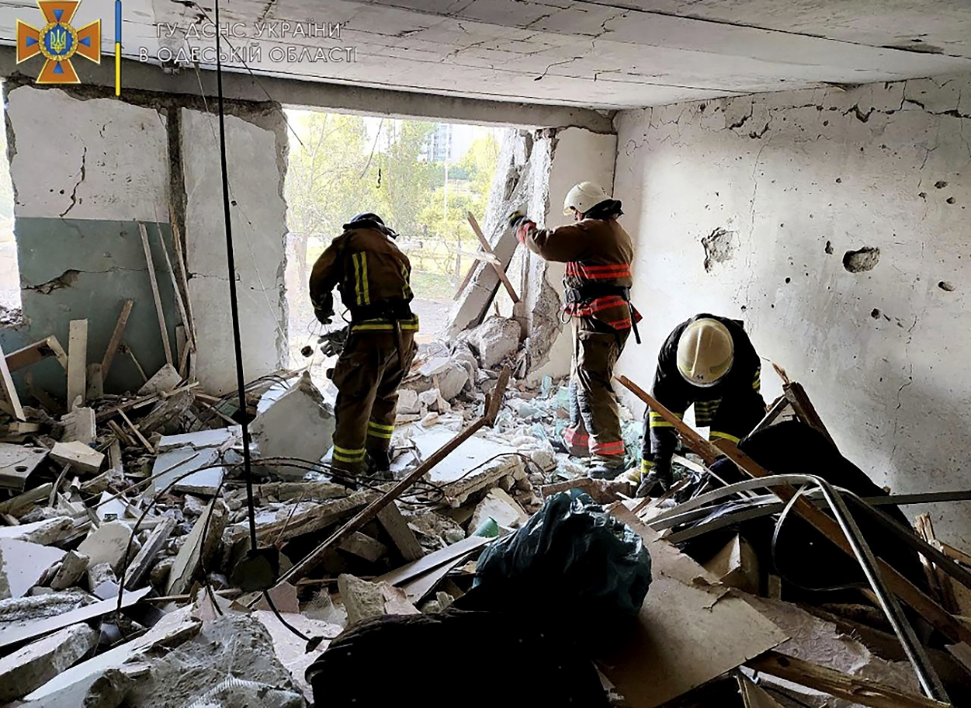 First responders work in a damaged residential building in Odesa, Ukraine, early Friday following Russian missile attacks.