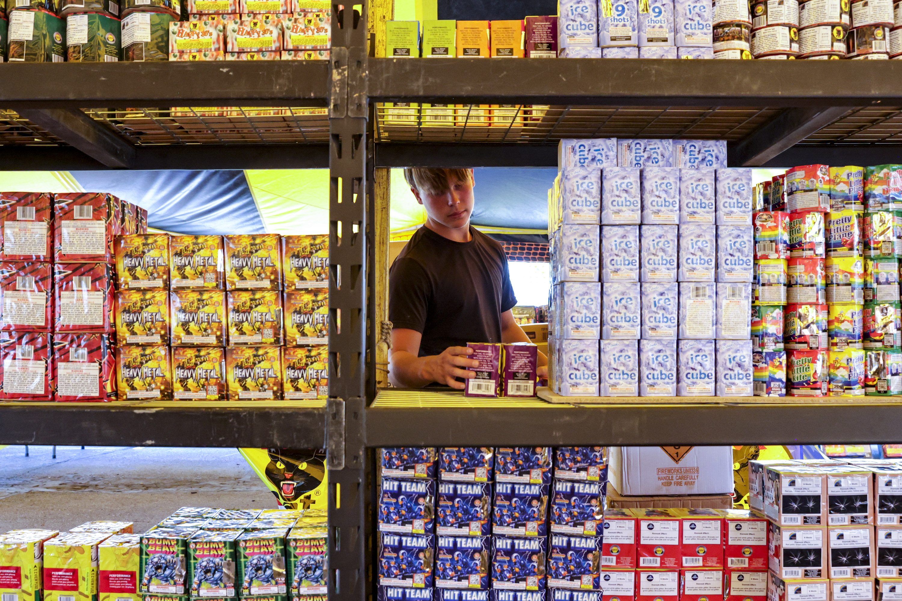 Riley Warner stacks fireworks in preparation for the Fourth of July weekend at a Pyro City fireworks tent in West Valley City on June 27.