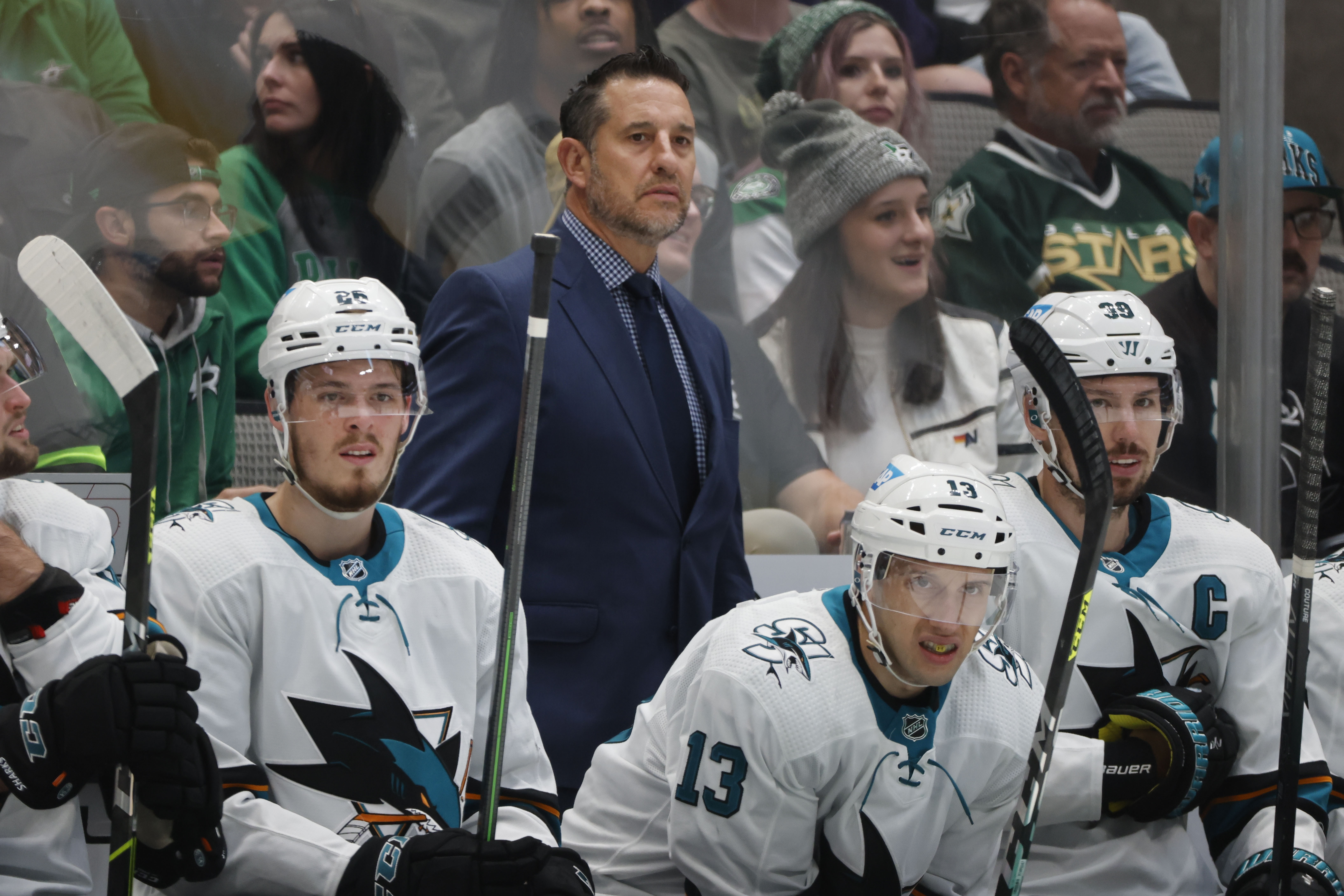 FILE - San Jose Sharks head coach Bob Boughner, center top, center Jasper Weatherby (26), Nick Bonino (13) and center Logan Couture (39) watch as they play the Dallas Stars during the first period of an NHL hockey game in Dallas, Saturday, April 16, 2022. The San Jose Sharks have abruptly fired coach Bob Boughner and his staff two months after the regular season ended. The team confirmed the moves Friday, July 1, 2022. , File