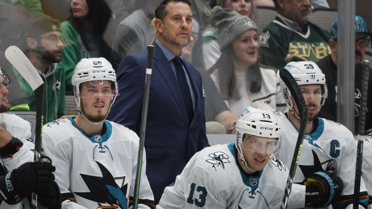 FILE - San Jose Sharks head coach Bob Boughner, center top, center Jasper Weatherby (26), Nick Bonino (13) and center Logan Couture (39) watch as they play the Dallas Stars during the first period of an NHL hockey game in Dallas, Saturday, April 16, 2022. The San Jose Sharks have abruptly fired coach Bob Boughner and his staff two months after the regular season ended. The team confirmed the moves Friday, July 1, 2022. , File