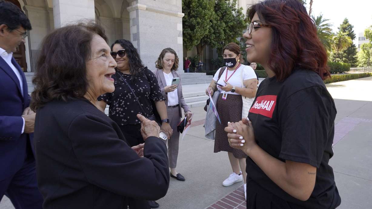 Civil rights activist Dolores Huerta, left, talks with Beatriz Hernandez, right, at a rally at the Capitol in Sacramento, Calif., on Wednesday, calling for health care for all low-income immigrants living in the country illegally. California will become the first state to offer free health care to all low-income immigrants regardless of their legal status after Gov. Gavin Newsom signed a $307.9 billion operating budget on Thursday.