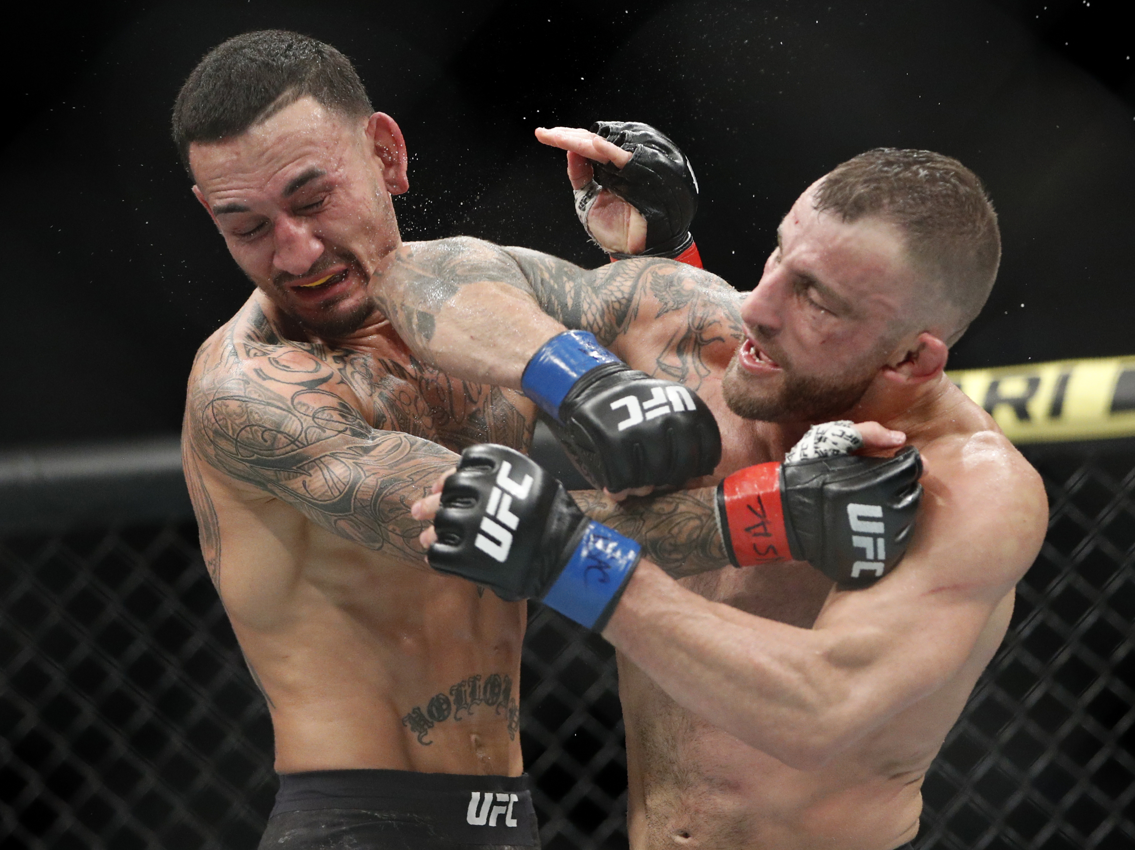 FILE - Alexander Volkanovski lands an elbow to Max Holloway in a mixed martial arts featherweight championship bout at UFC 245, Saturday, Dec. 14, 2019, in Las Vegas. Alexander Volkanovski has already beaten Max Holloway twice in UFC featherweight title fights, and it still wasn't enough to settle this rivalry in practically anybody's mind. 