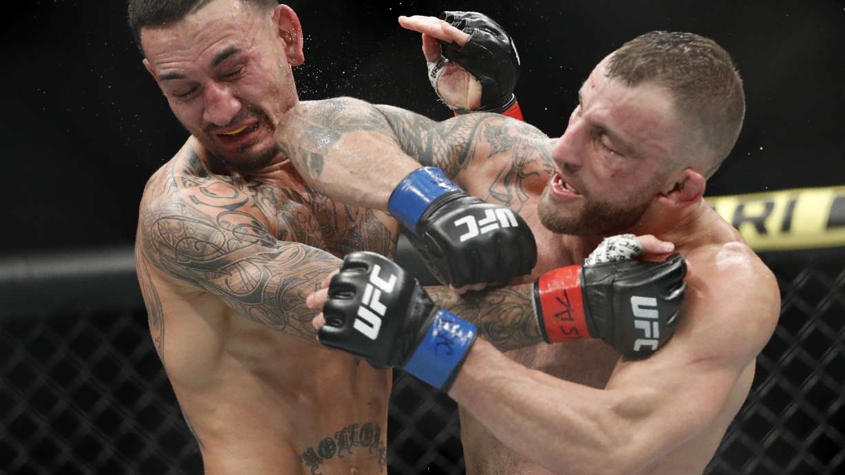 FILE - Alexander Volkanovski lands an elbow to Max Holloway in a mixed martial arts featherweight championship bout at UFC 245, Saturday, Dec. 14, 2019, in Las Vegas. Alexander Volkanovski has already beaten Max Holloway twice in UFC featherweight title fights, and it still wasn't enough to settle this rivalry in practically anybody's mind.