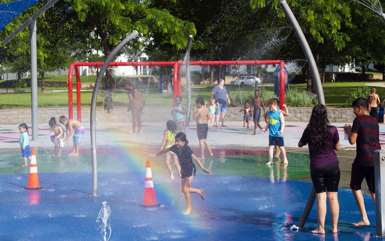 Children and adults take advantage of the warm weather to cool off at the Trago Spray Park on June 10 in Lincoln, Neb. The fast-changing coronavirus has kicked off summer in the U.S. with lots of infections but relatively few deaths compared to its prior incarnations. COVID-19 is still killing hundreds of Americans each day, but for many people the virus is not nearly as dangerous as it was.