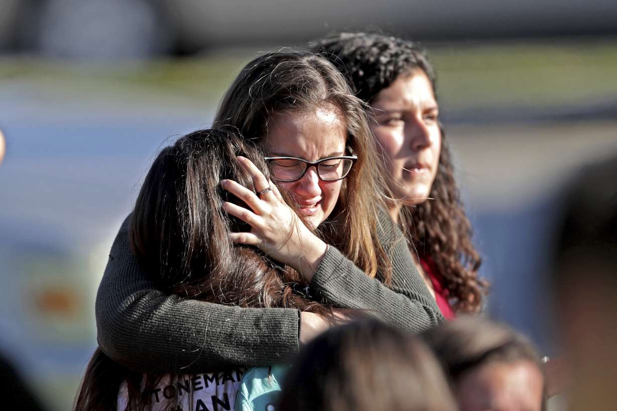 Students released from a lockdown embrace following a shooting at Marjory Stoneman Douglas High School in Parkland, Fla. The 12 jurors and 10 alternates chosen this past week to decide whether Cruz is executed will be exposed to horrific images and emotional testimony, but must deal with any mental anguish alone.
