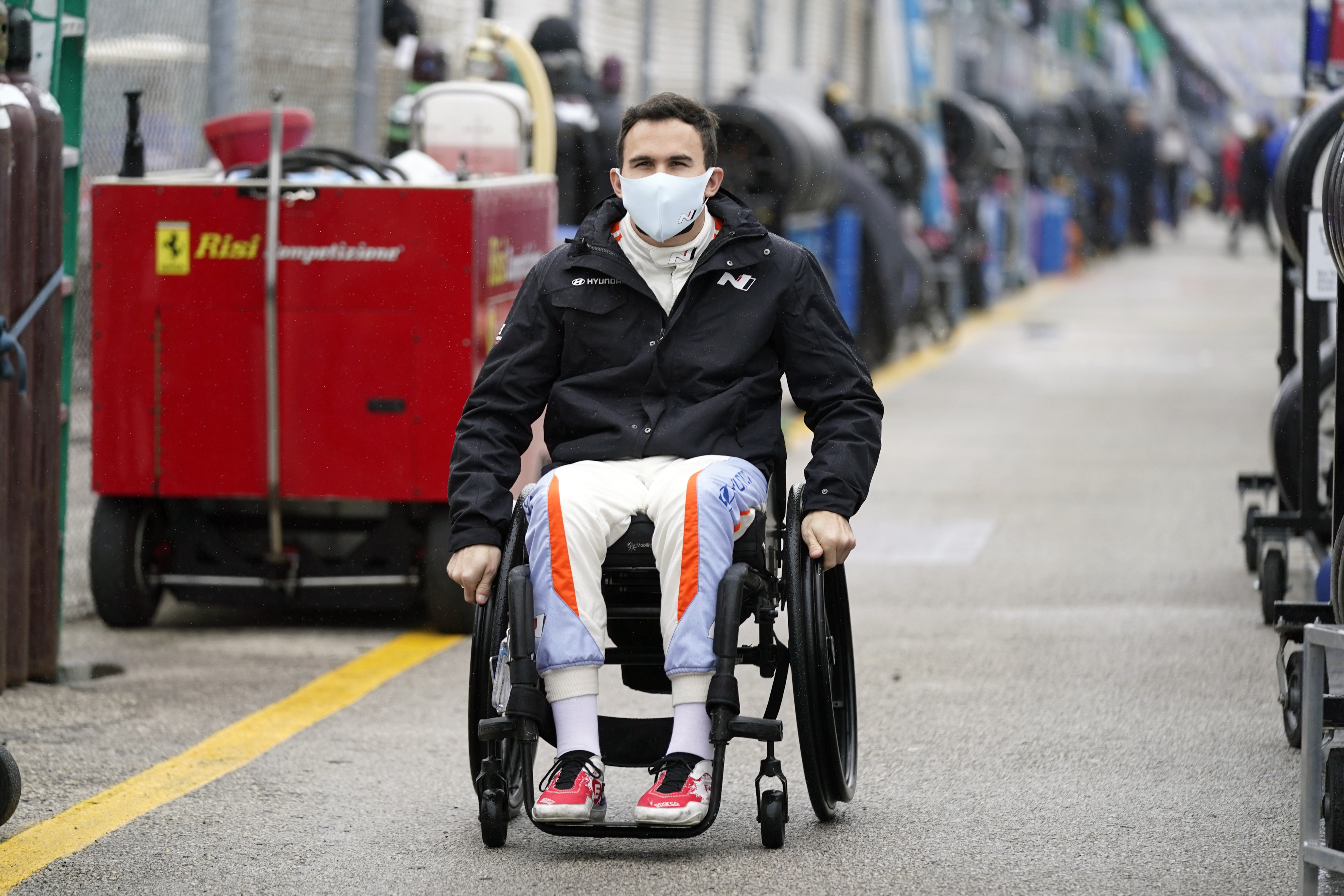 FILE - Robert Wickens makes his way to his pit stall during practice for the Rolex 24 hour auto race at Daytona International Speedway, Thursday, Jan. 27, 2022, in Daytona Beach, Fla. Wickens used hand controls last weekend to win his first race since a 2018 spinal cord injury temporarily ended his racing career. Across an ocean, former IndyCar driver Sam Schmidt and motorcycle racer Wayne Rainey also piloted vehicles during the annual Goodwood Festival of Speed in England. 