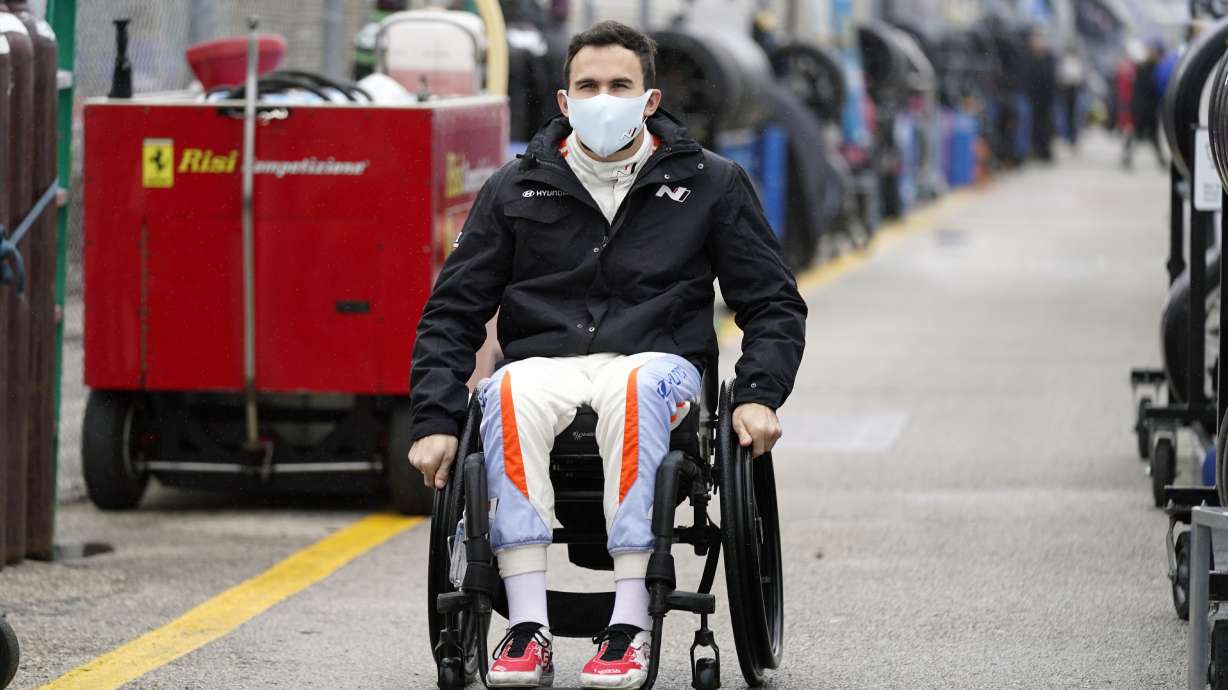 FILE - Robert Wickens makes his way to his pit stall during practice for the Rolex 24 hour auto race at Daytona International Speedway, Thursday, Jan. 27, 2022, in Daytona Beach, Fla. Wickens used hand controls last weekend to win his first race since a 2018 spinal cord injury temporarily ended his racing career. Across an ocean, former IndyCar driver Sam Schmidt and motorcycle racer Wayne Rainey also piloted vehicles during the annual Goodwood Festival of Speed in England.