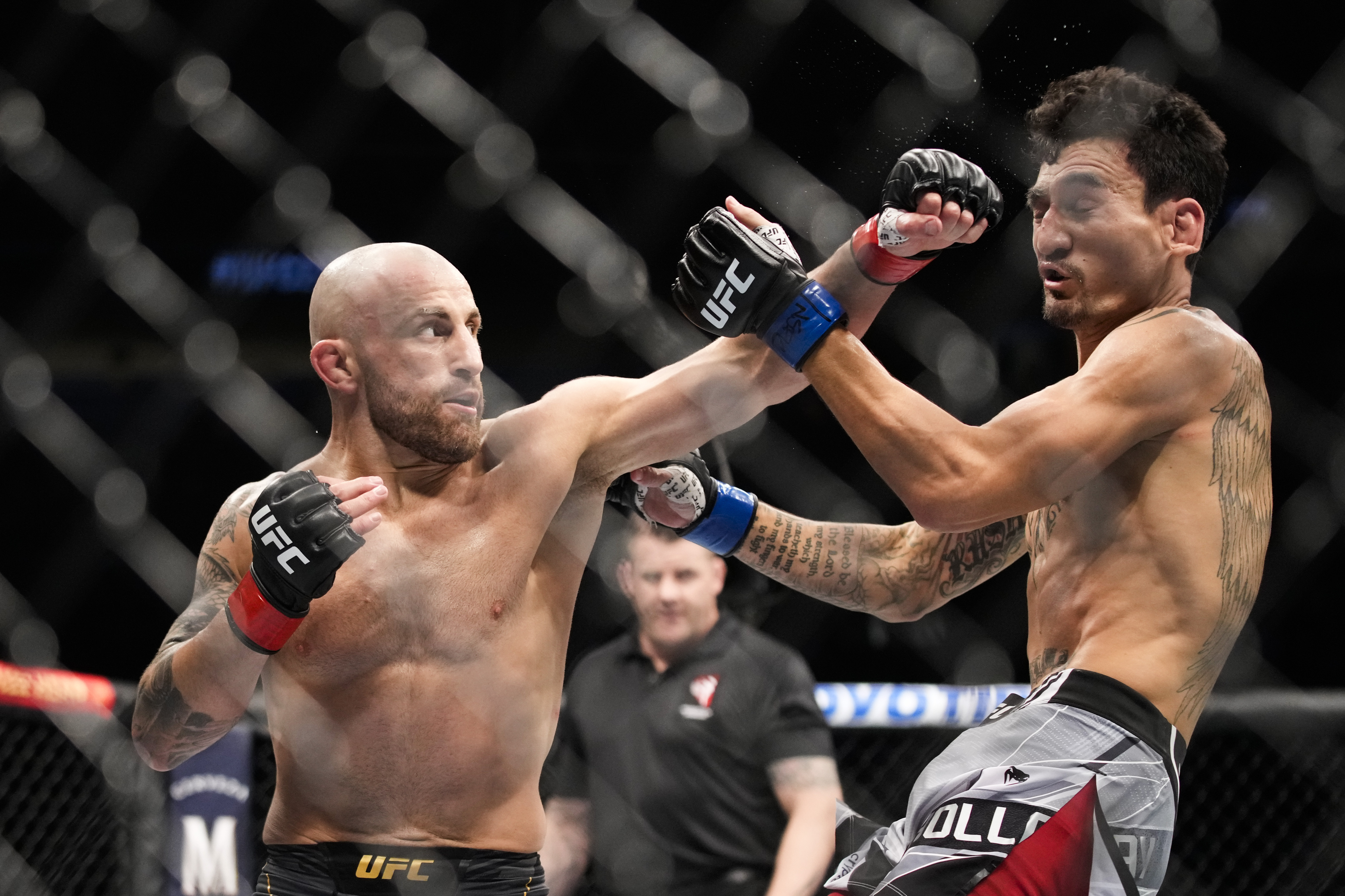 Alexander Volkanovski, left, hits Max Holloway in a featherweight title bout during the UFC 276 mixed martial arts event Saturday, July 2, 2022, in Las Vegas.