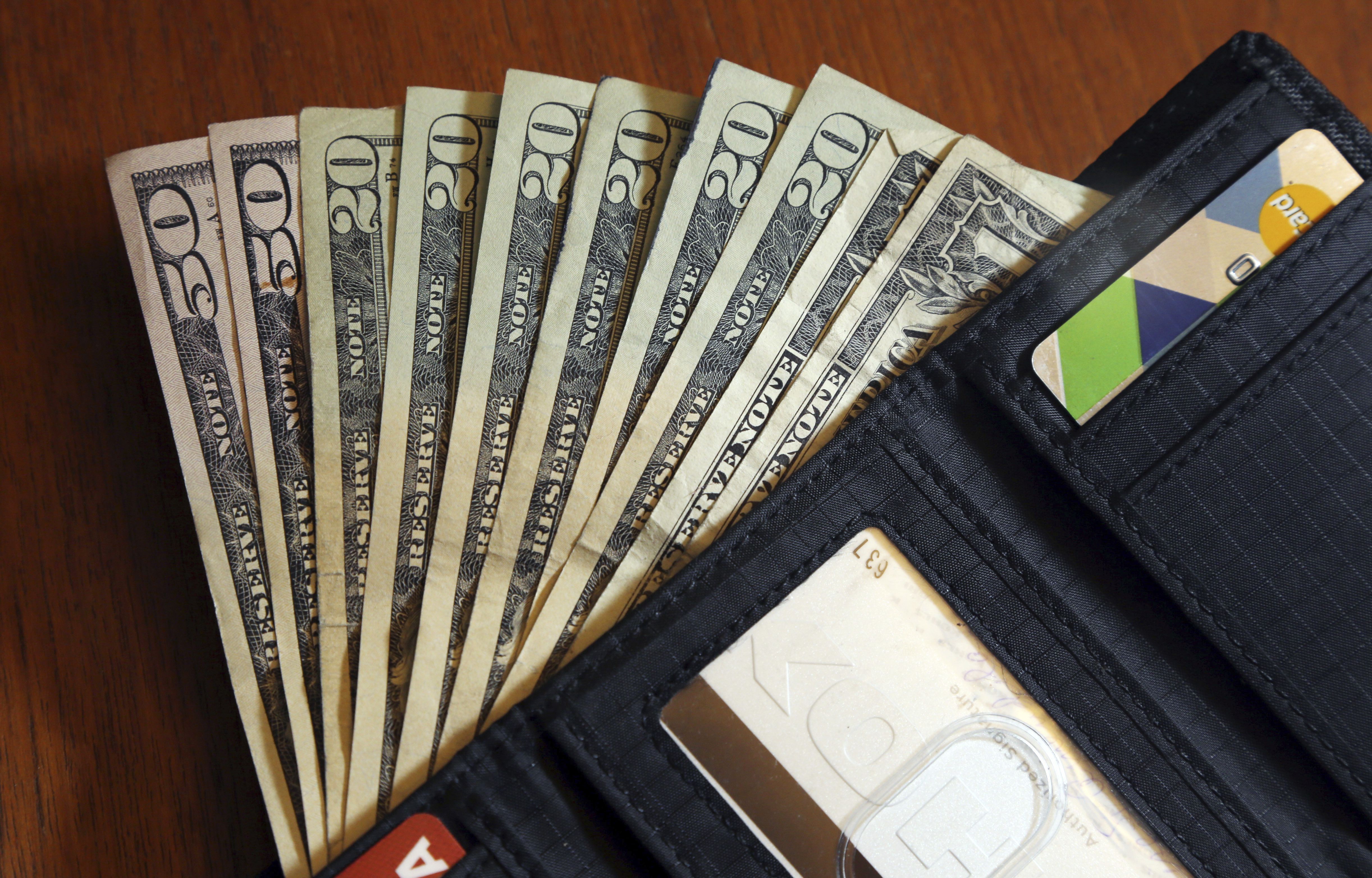 Cash is fanned out from a wallet in North Andover, Mass., on June 15, 2018. Heading into the second half of 2022, it’s a good time to pause and check in on your financial life.