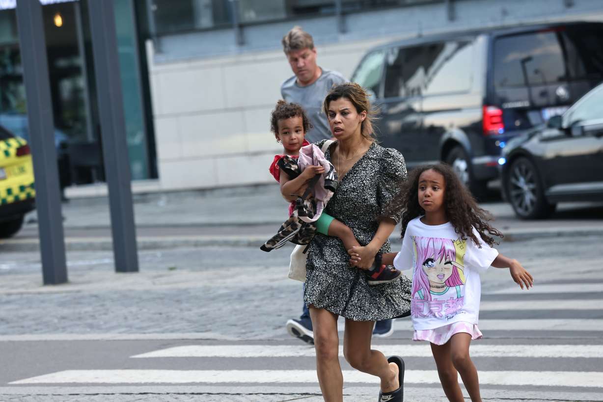 A woman and children flee the Field's shopping center after a shooting, in Copenhagen, Denmark, Sunday.