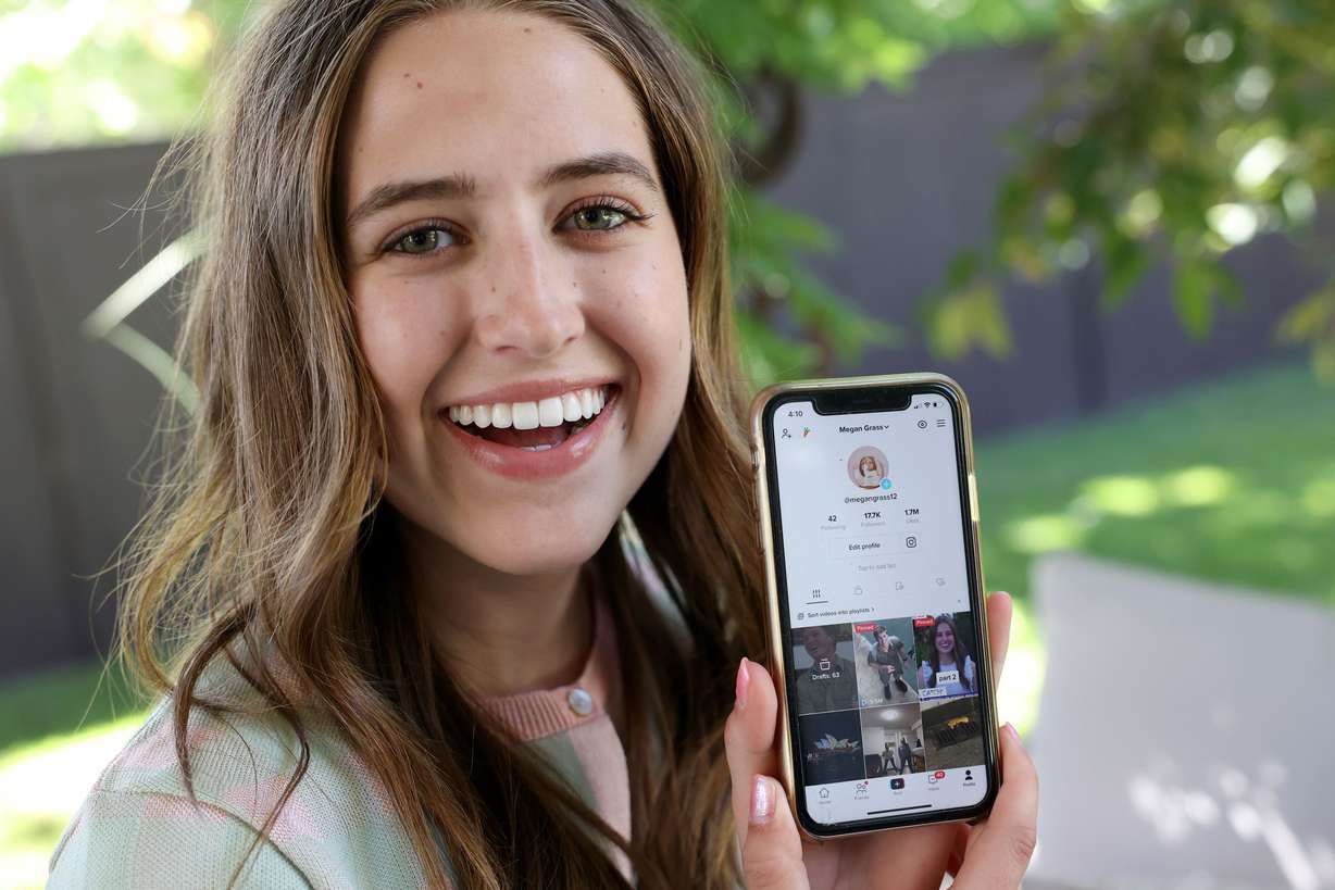 Megan Grass shows her TikTok account which, at the time of the photo, has 1.7 million likes and 17.7 thousand followers, at home in Cottonwood Heights on June 21. Grass posted a TikTok video, that has gone viral, of her asking Robert Irwin, son of “The Crocodile Hunter” Steve Irwin, for his number.