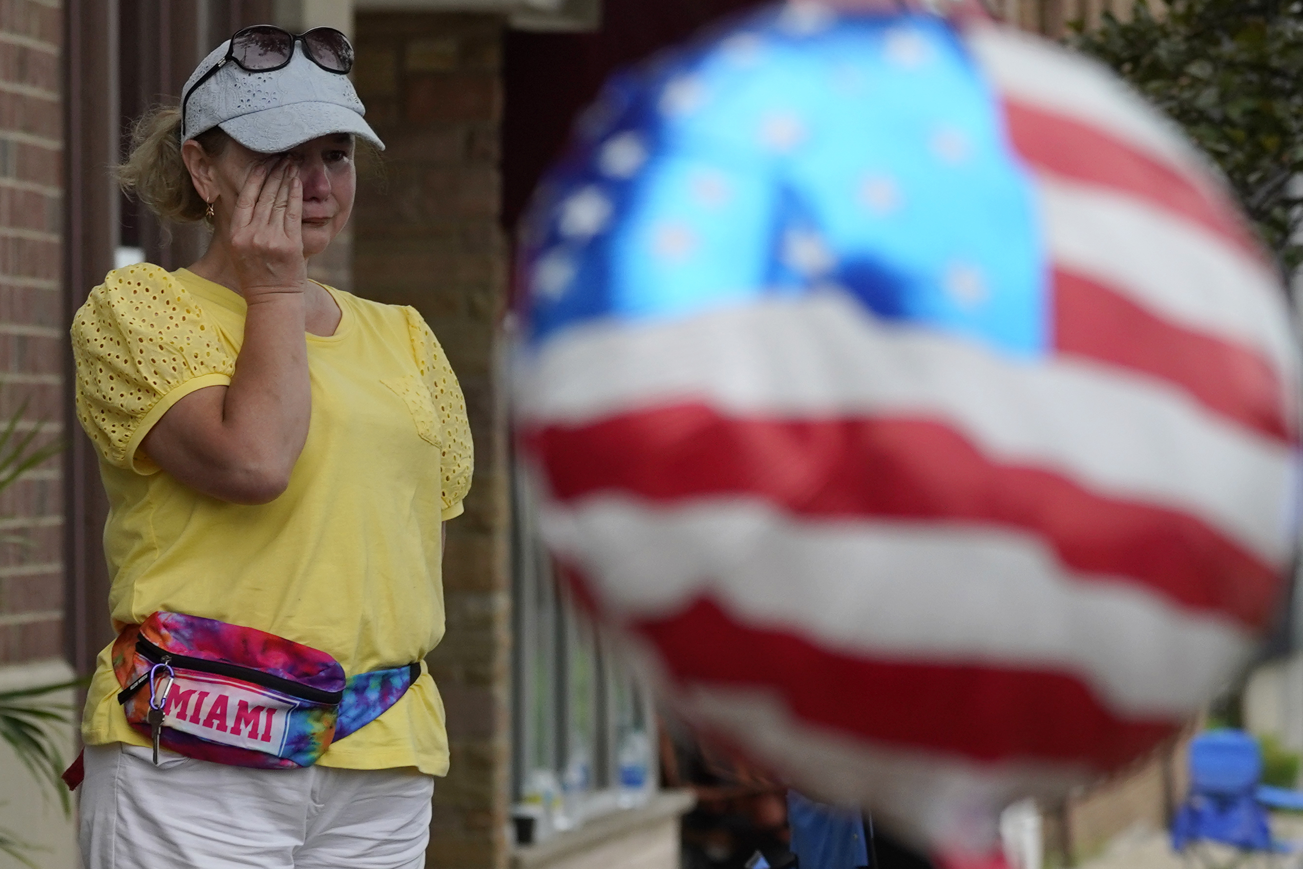 A woman wipes away tears after a mass shooting at the Highland Park Fourth of July parade in Highland Park, Ill., a Chicago suburb, Monday.
