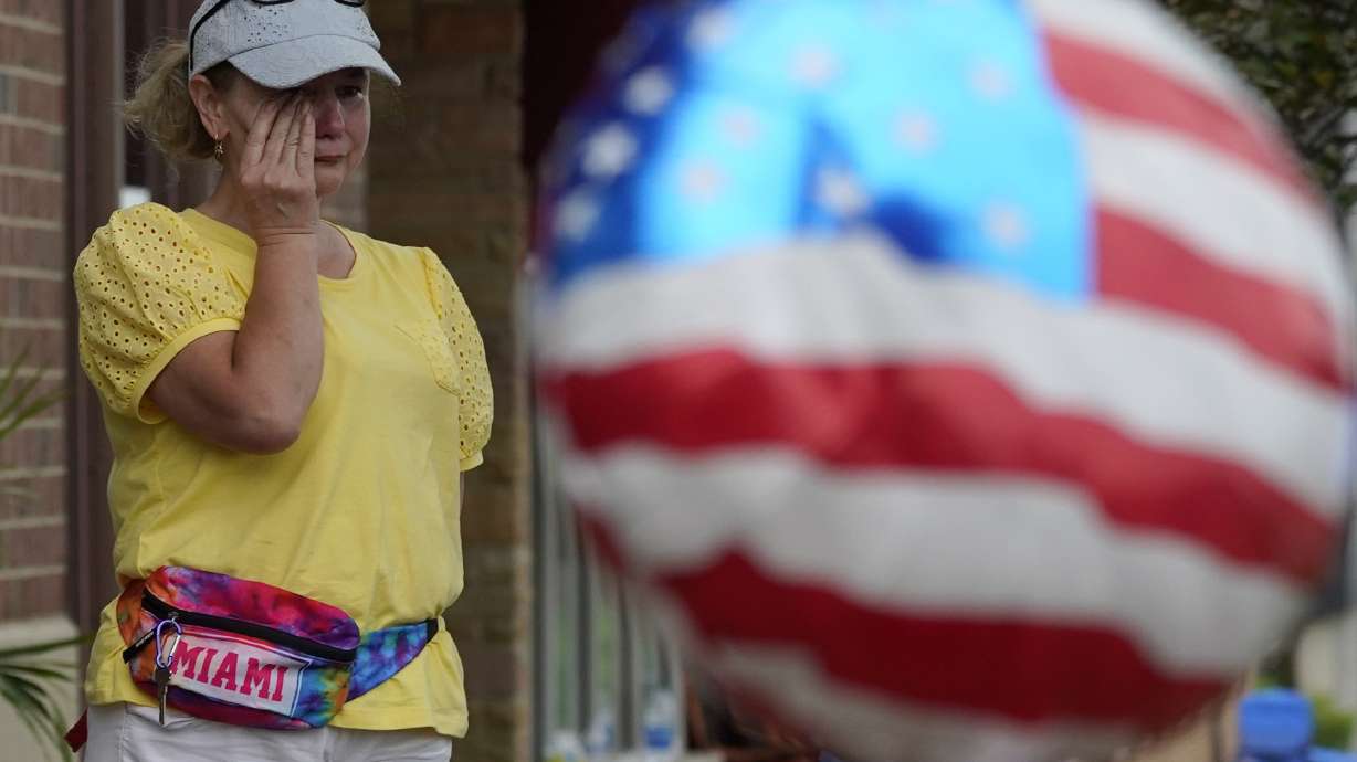 A woman wipes away tears after a mass shooting at the Highland Park Fourth of July parade in Highland Park, Ill., a Chicago suburb, Monday.