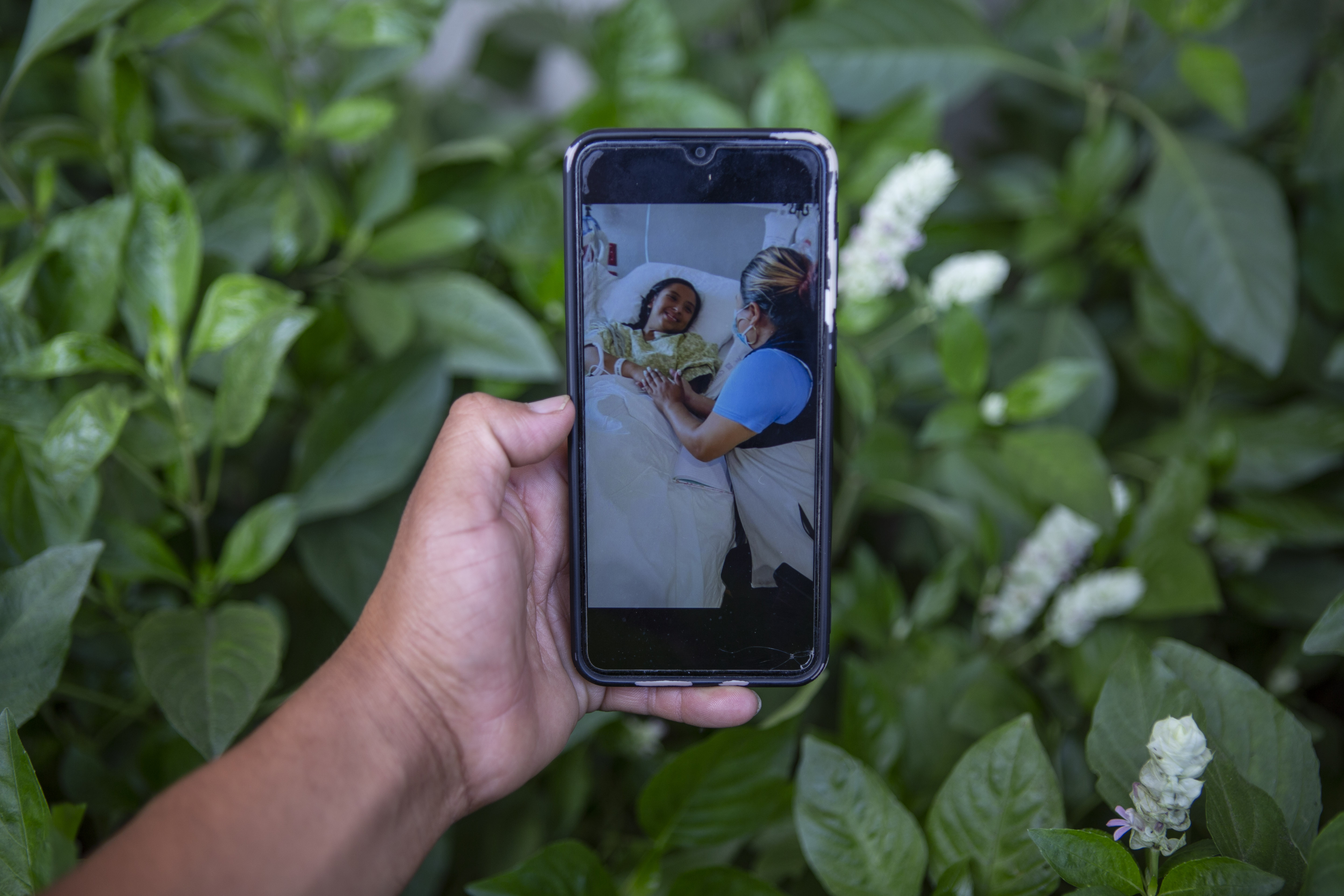 Mynor Cardona shows a photo on his cellphone of her daughter, Yenifer Yulisa Cardona Tomás, at the hospital while receiving a visit, in Guatemala City, Monday. She is one of the survivors of the more than 50 migrants who were found dead inside a tractor-trailer near San Antonio, Texas.