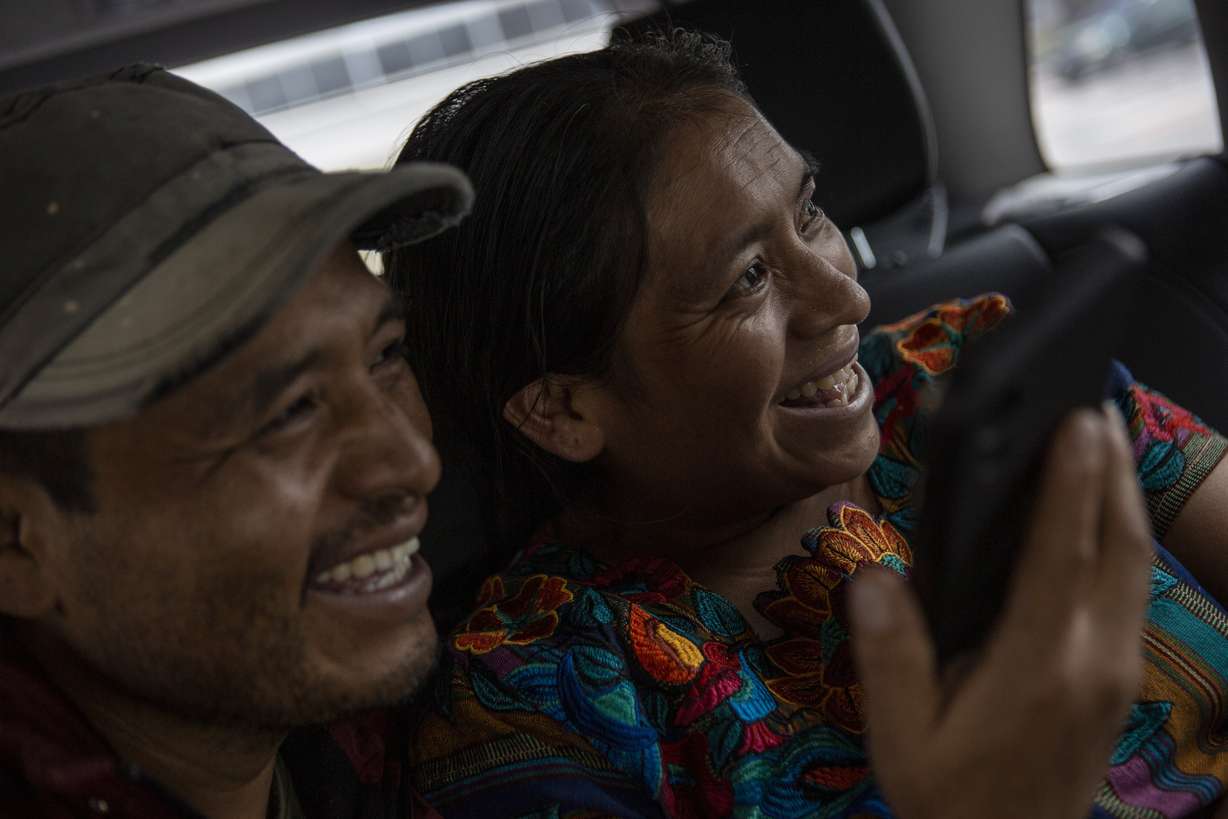 Mynor Cardona and Ufemia Tomas, parents of Yenifer Yulisa Cardona Tomás, smile as they talk with her through a call to the hospital where she is being treated in Guatemala City, Monday.