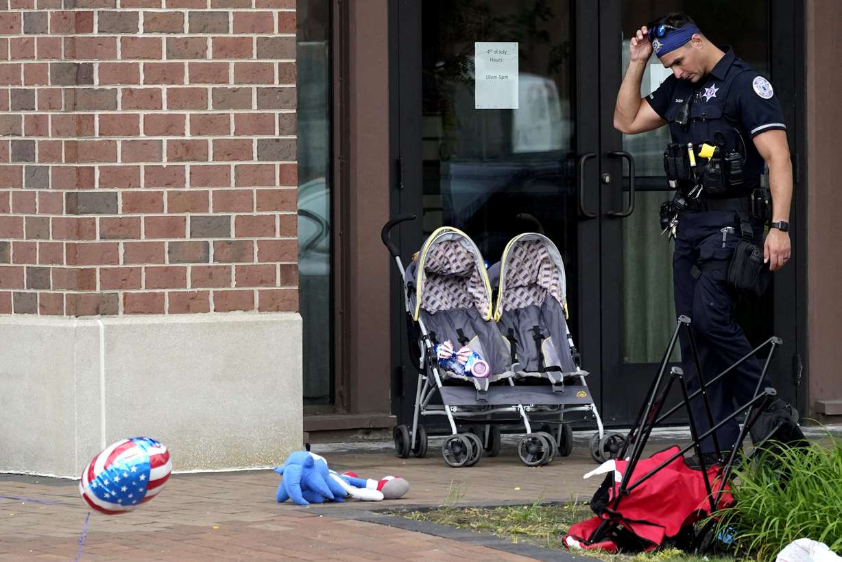 A police officer reacts as he walks in downtown Highland Park, a suburb of Chicago, Monday, where a mass shooting took place at a Highland Park Fourth of July parade.