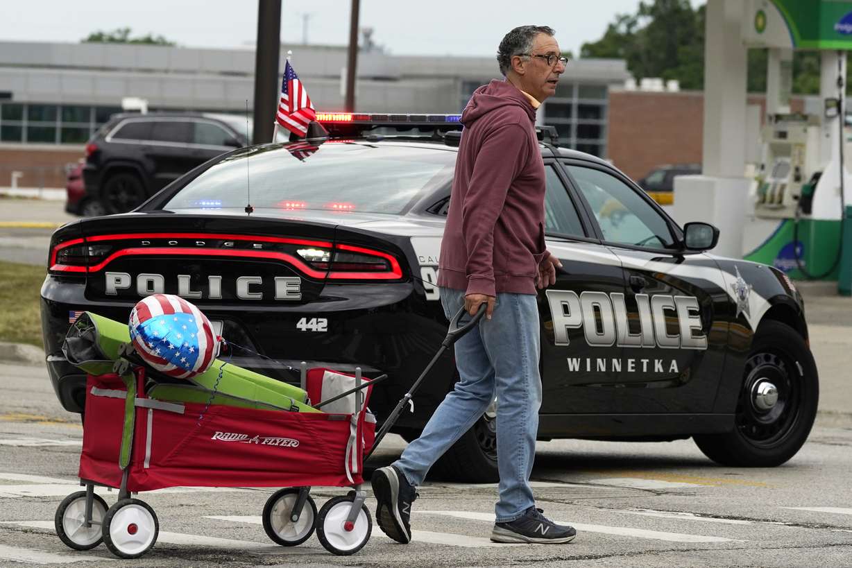 A man carries his belongings after a mass shooting at the Highland Park Fourth of July parade in downtown Highland Park, Ill., a Chicago suburb on Monday.