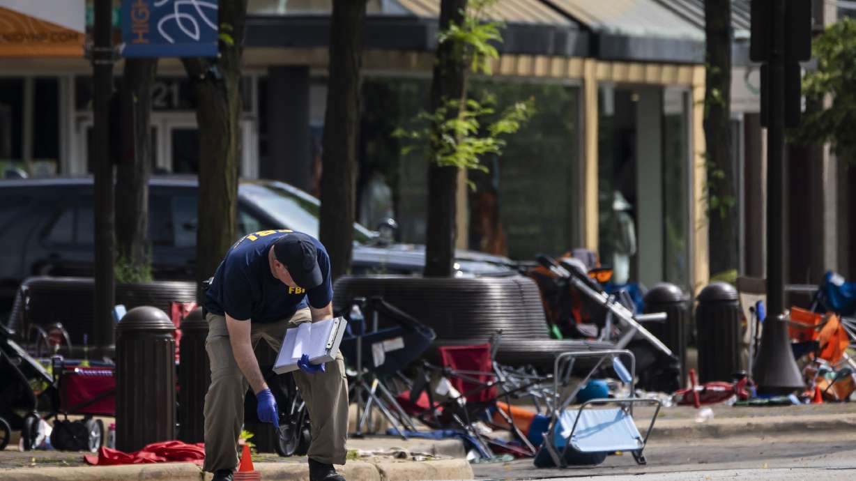 Members of the FBI's Evidence Response Team Unit investigate in downtown Highland Park, Ill., the day after a deadly mass shooting on Tuesday. Police say the gunman who attacked an Independence Day parade in suburban Chicago fired more than 70 rounds with an AR-15-style gun.