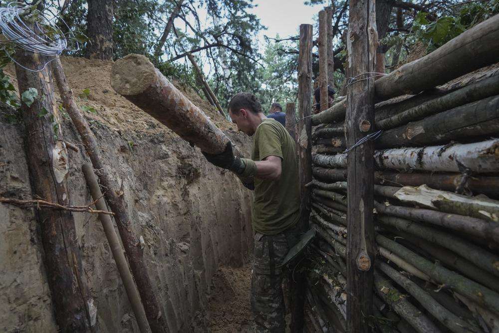 Ukrainian servicemen strengthen trenches at their position near the frontline in Kharkiv region, Ukraine, Tuesday. The governor of the last remaining eastern province partly under Ukraine's control urged his more than 350,000 residents to flee as Russian troops escalated their offensive.