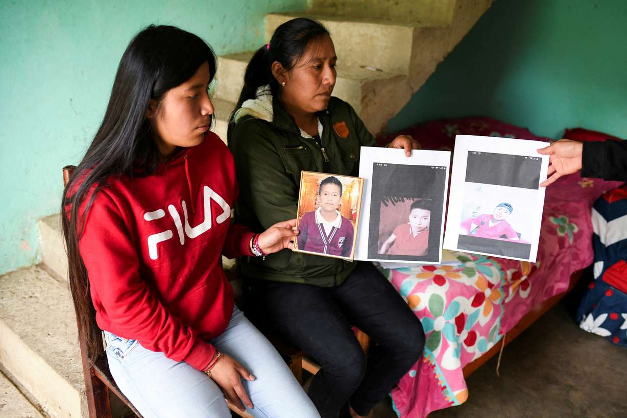 Yolanda Olivares, holds pictures of her sons Jair, 19, Yovani Valencia, 16, and her nephew Misael Olivares, 16, at her house as she believes they were traveling inside the trailer where several migrants died in San Antonio, Texas, in the town of San Marcos Atexquilapan, in Veracruz state, Mexico June 30.